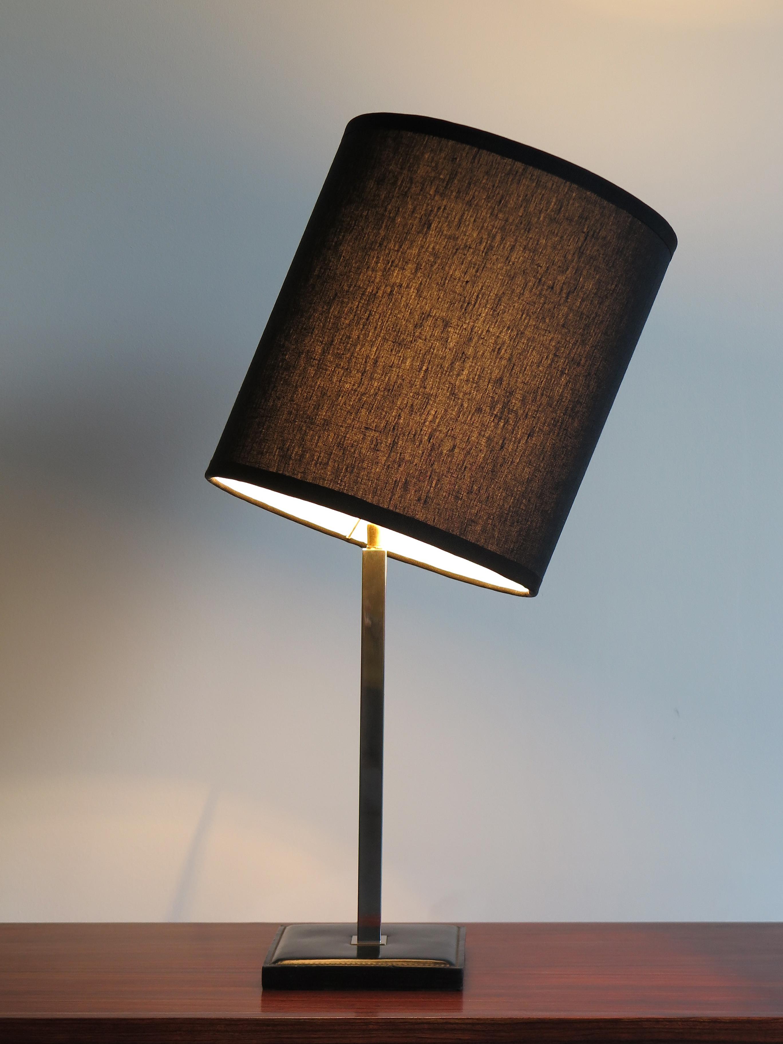 Lampe de table conçue par Delvaux et fabriquée en Belgique avec une base en cuir, une structure chromée et un abat-jour orientable en tissu noir neuf, vers les années 1960.
Signature du producteur sous la base.

Veuillez noter que la base et la