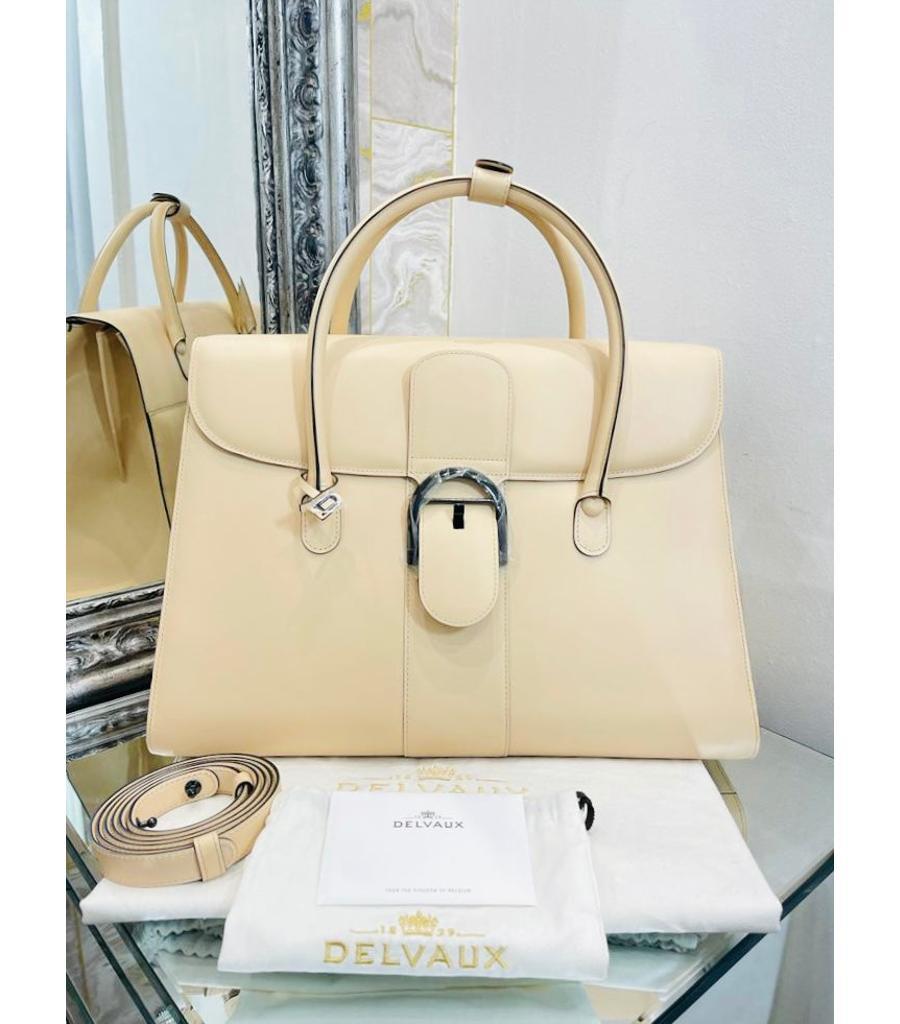 Delvaux Leather Brilliant Bag

Large model in cream/light beige in shiny smooth leather with signature 

'D' buckle in black. Classic trapezoid shape with top carry handle and a removable

shoulder strap.

Size - Height 30cm, Width 40cm, Depth