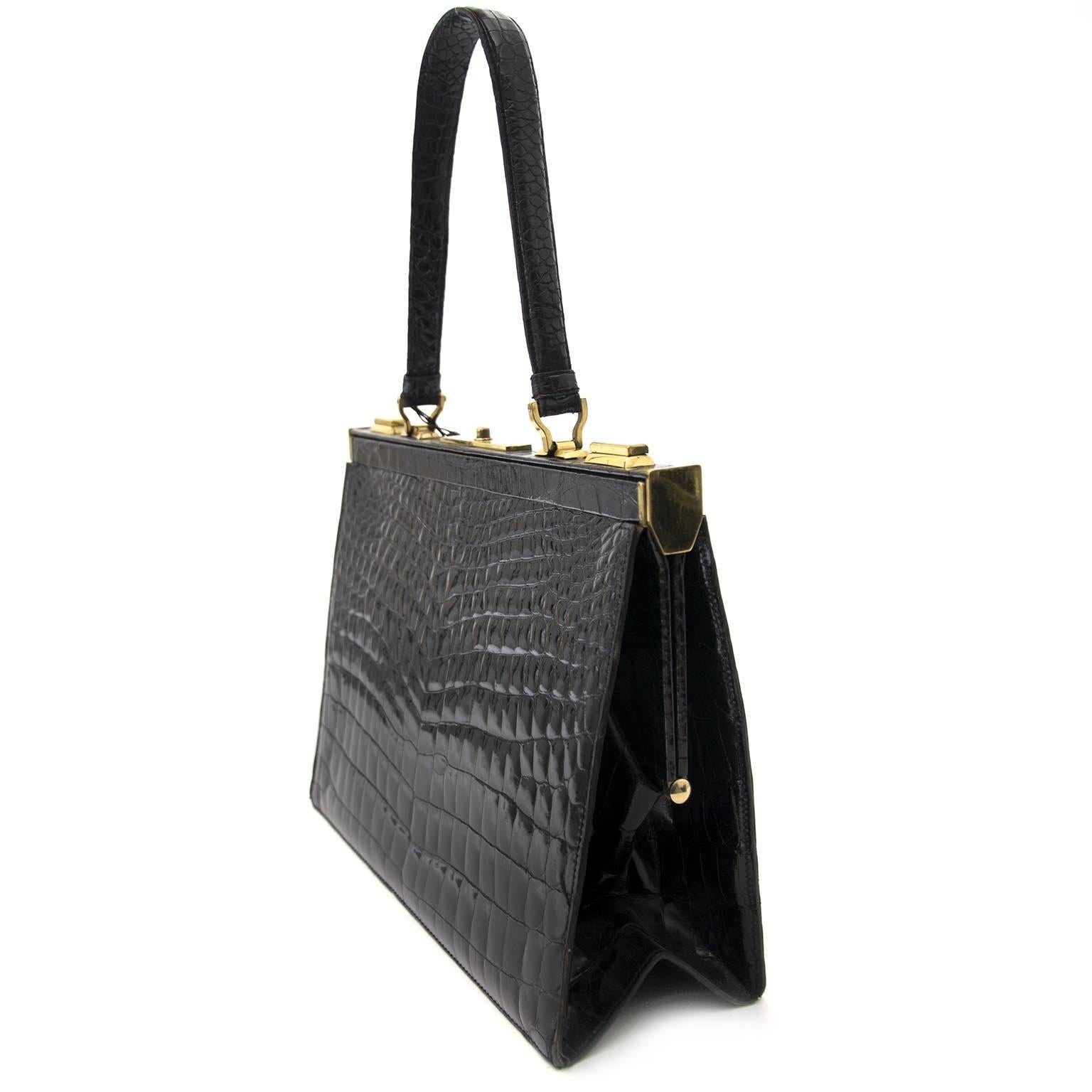 Good preloved condition

Delvaux 'Mon Grand Bonheur' Croco Top Handle Bag

This beautiful Delvaux top handle bag comes in black croco leather.

The bag has one leather top handle and closes with a push lock.

The interior contains one large