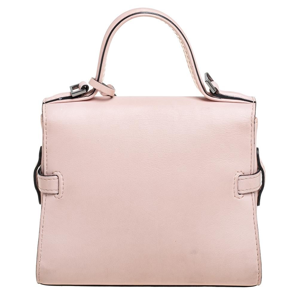 This pink handbag by Delvaux has a structured silhouette and elaborate interiors to create a classically chic look. This alluring and beautifully fashioned leather bag is surely a must-have. It is held by a top handle and crafted to