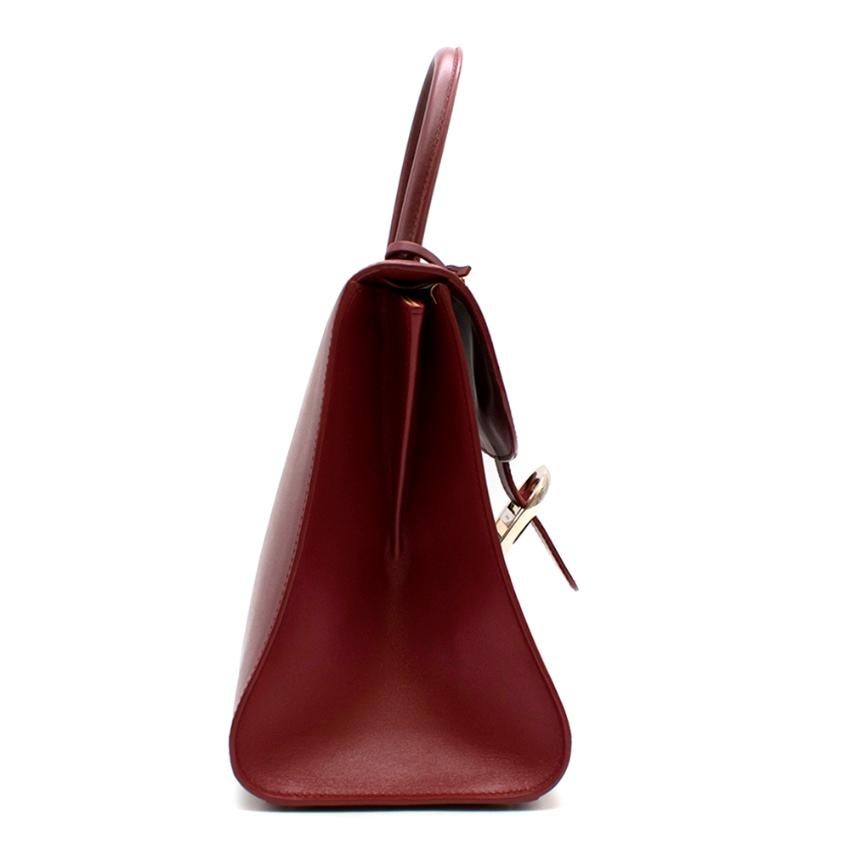 Delvaux Red Brilliant MM Top Handle Bag Very rare colour bought in Beijing China

- Burgundy Leather 
- Top Handle 
- Front Flap with Signature D Buckle 
- Metal Protective Feet 
- Internal Zip Pocket, Slip Pocket 
- Key Fob Inside 
- Tonal