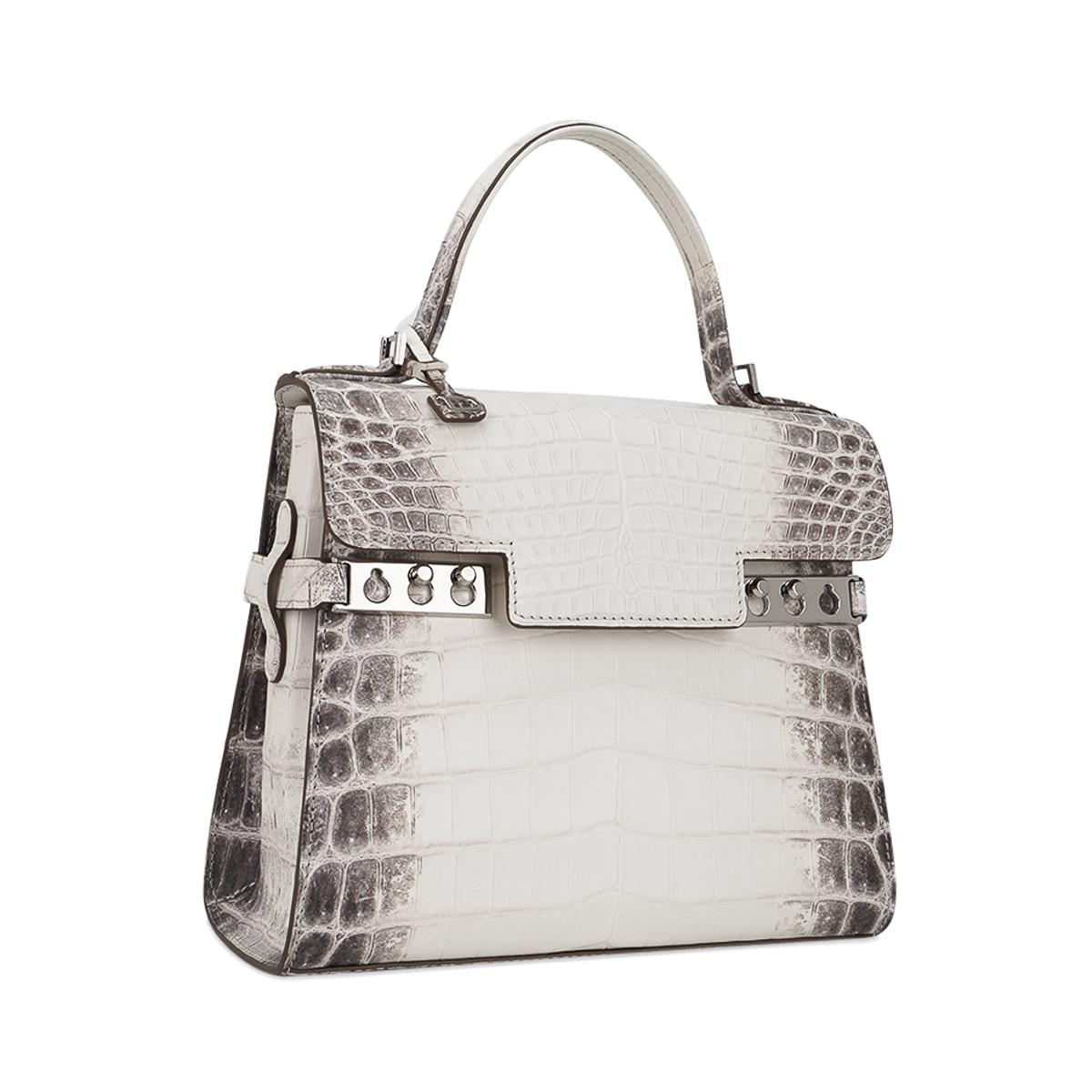 Mightychic offers a Limited Edition Delvaux Tempete PM bag featured in Blanc Casse Himalayan Crocodile.
Exquisite and sought after, the Himalaya Crocodile Tempete is a one of one created, making this a collectors treasure.
Inspired by a sailboat's