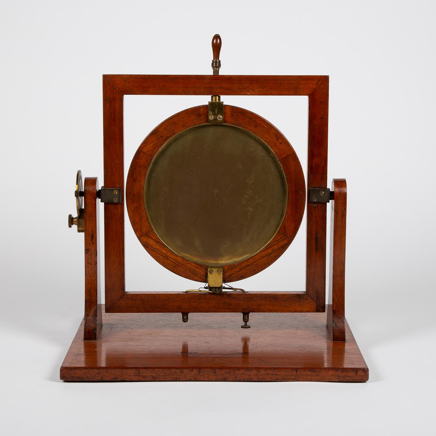 An Earth Inductor (Delzenne's Circle) by Elliott Brothers of London, circa 1910.

The rotating circle is mounted with a brass backed mirror.

The right hand side of the frame has a gilt brass circle divided by an 180 degree scale, subdivided by