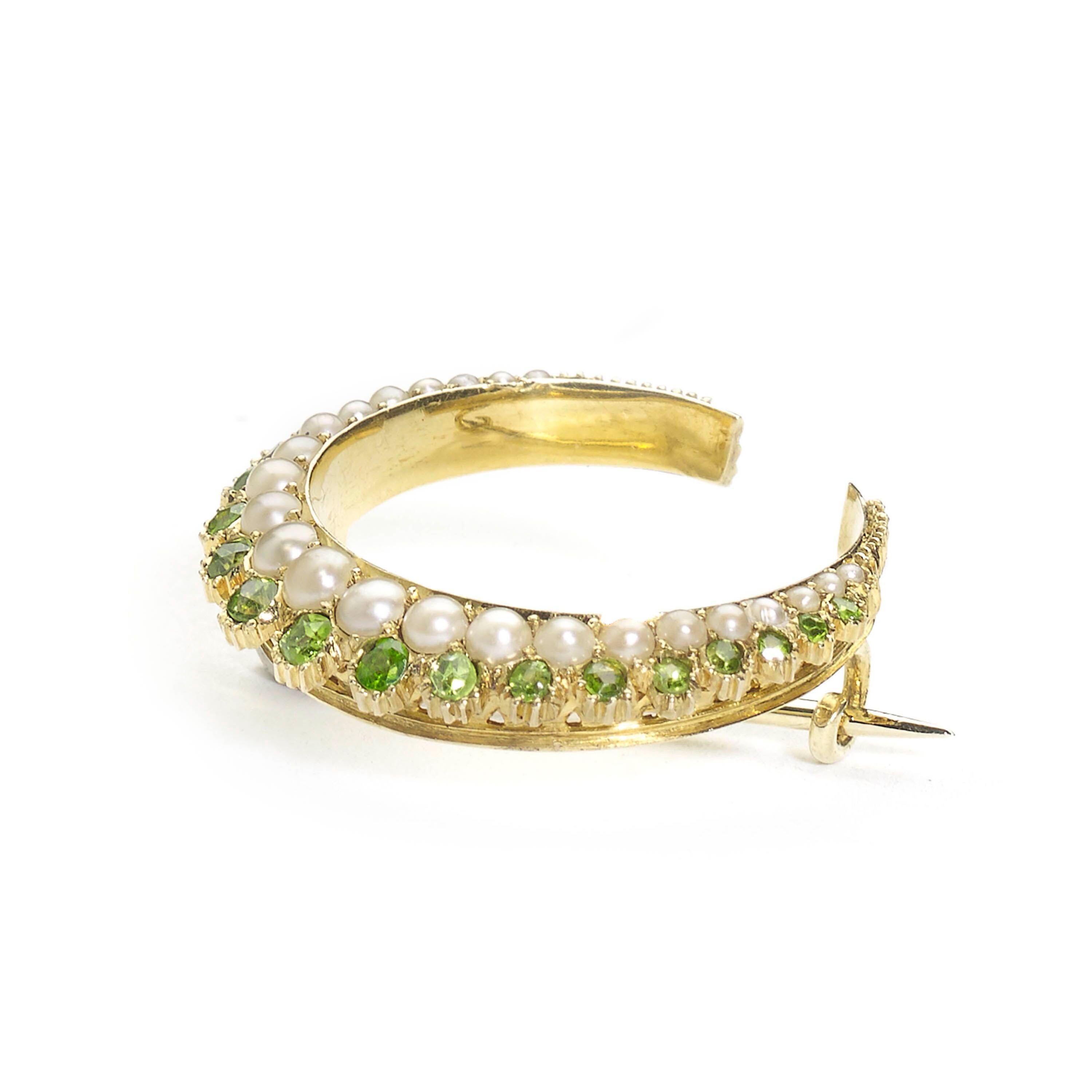 A Victorian demantoid garnet and pearl crescent brooch, designed as two rows, with an inner graduated row of half pearls and an outer graduated row of round-cut demantoid garnets, with a flat inner edge and a pierced outer gallery mounted in 15ct