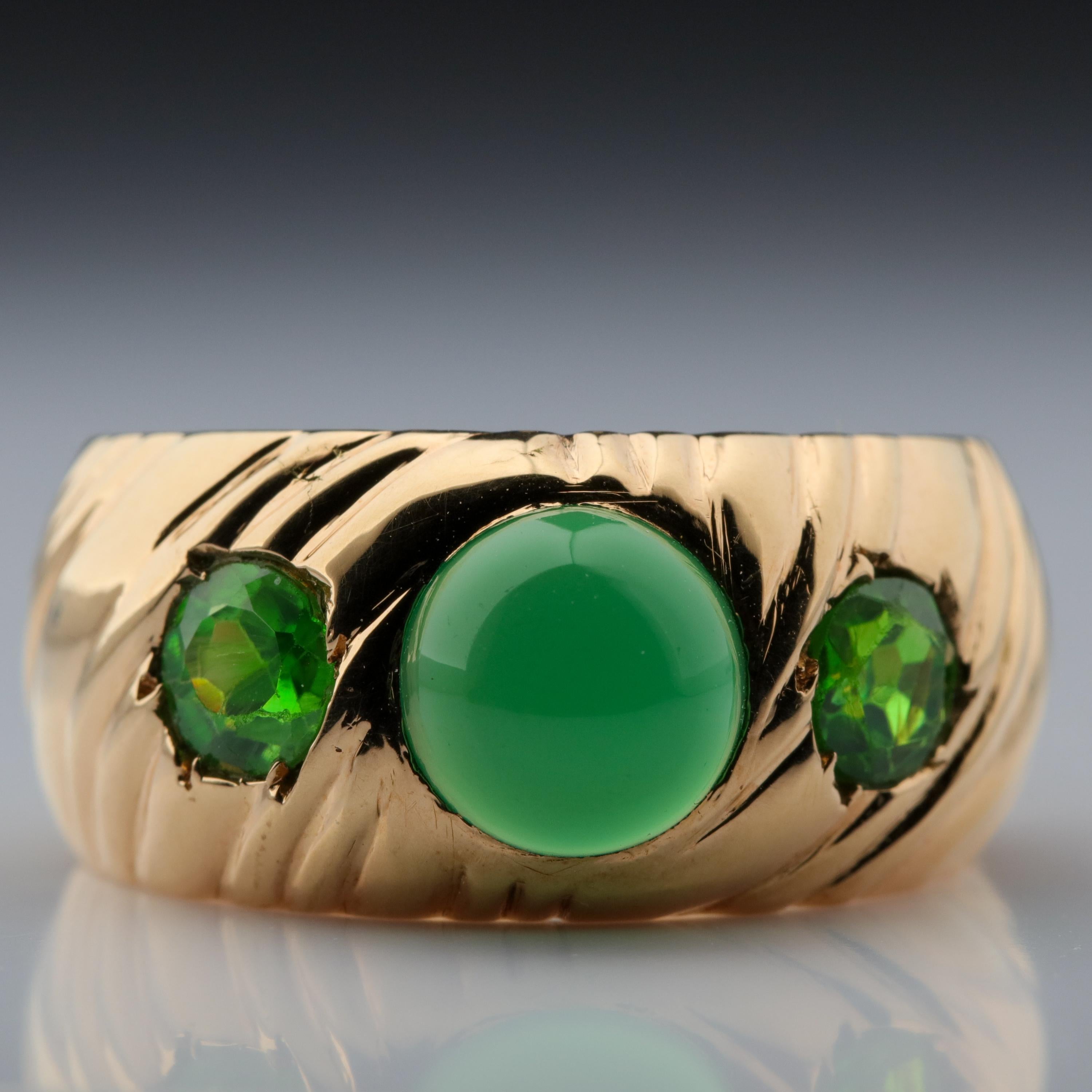 Hand-crafted in smooth, coppery-rose gold in Russia just around the turn of the century (circa 1890), this startlingly handsome and unique bias-ribbed cigar band ring is set with a central luminous, emerald-green chrysoprase cabochon measuring  7.47