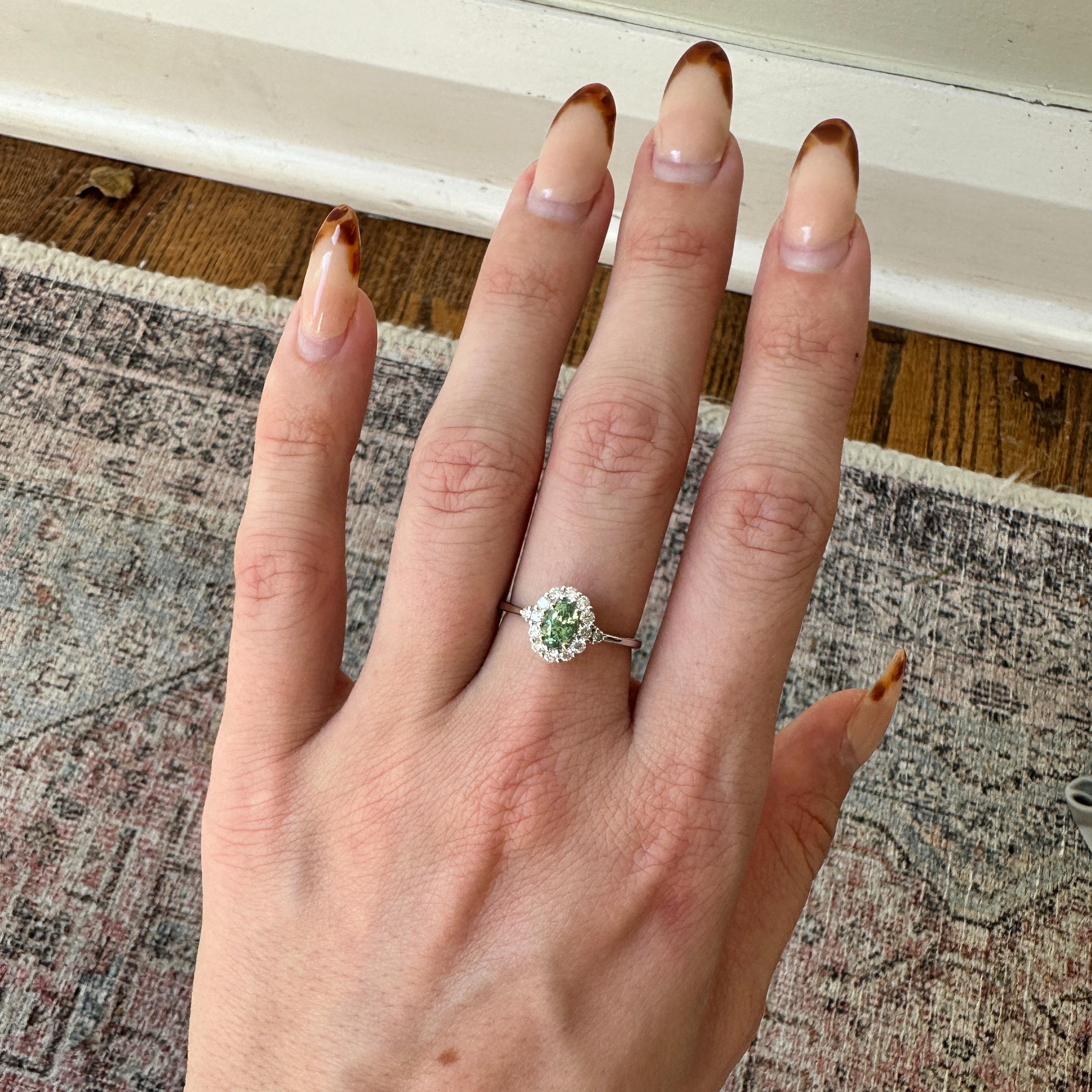 This elegant ring features a captivating 0.59 carat Demantoid, encircled by a halo of natural earth mined diamonds. The setting is crafted in a solid 14K gold band, providing a modern yet timeless appeal.

Specifications

Item Type: Ring
Center