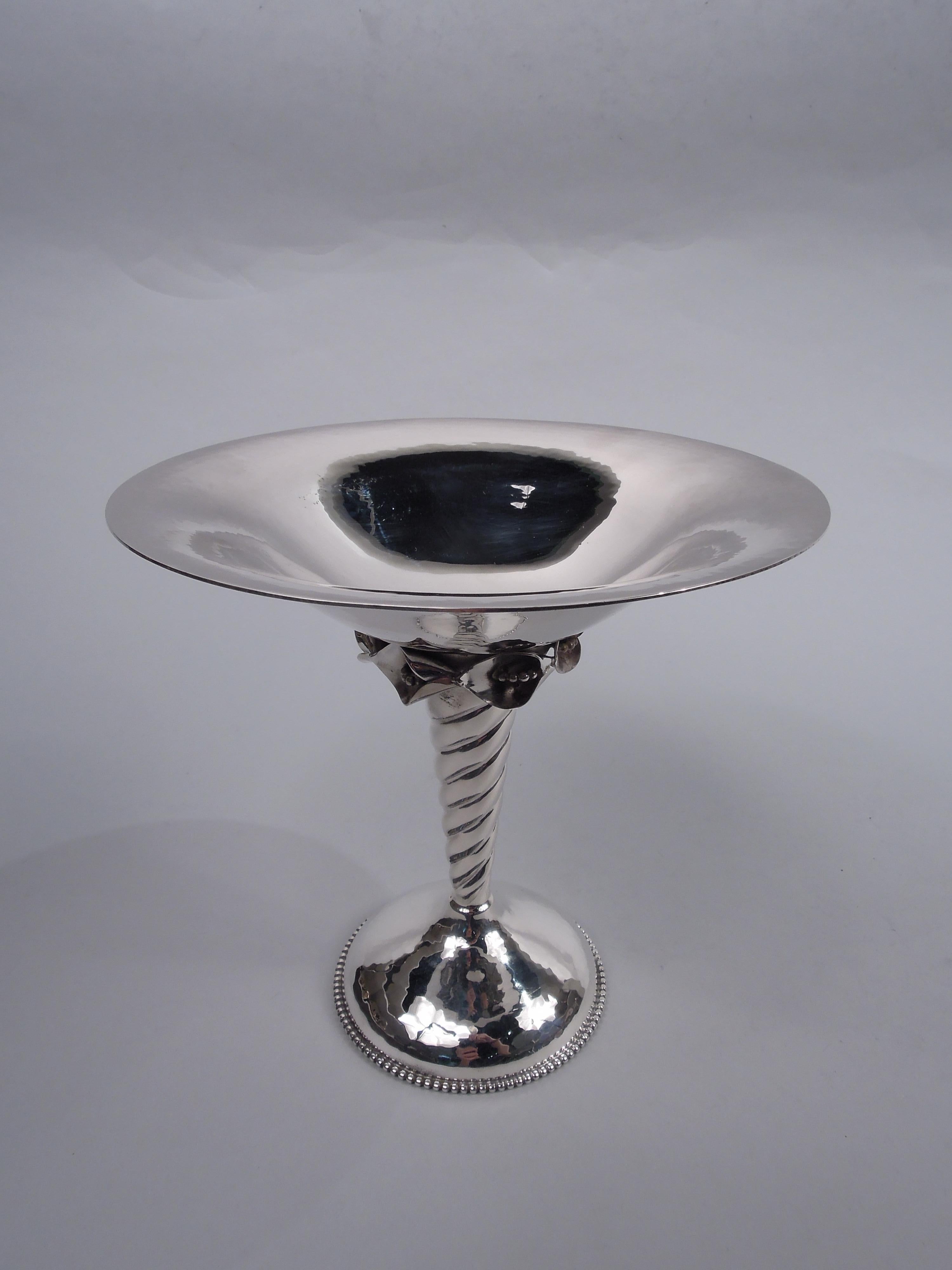 Midcentury Modern sterling silver compote. Made by William G. DeMatteo in Bergenfield, New Jersey. Round and wide bowl on twisted shaft mounted to domed and beaded foot. Mounted to bowl underside is floral band comprising seed-spilling buds. Visible