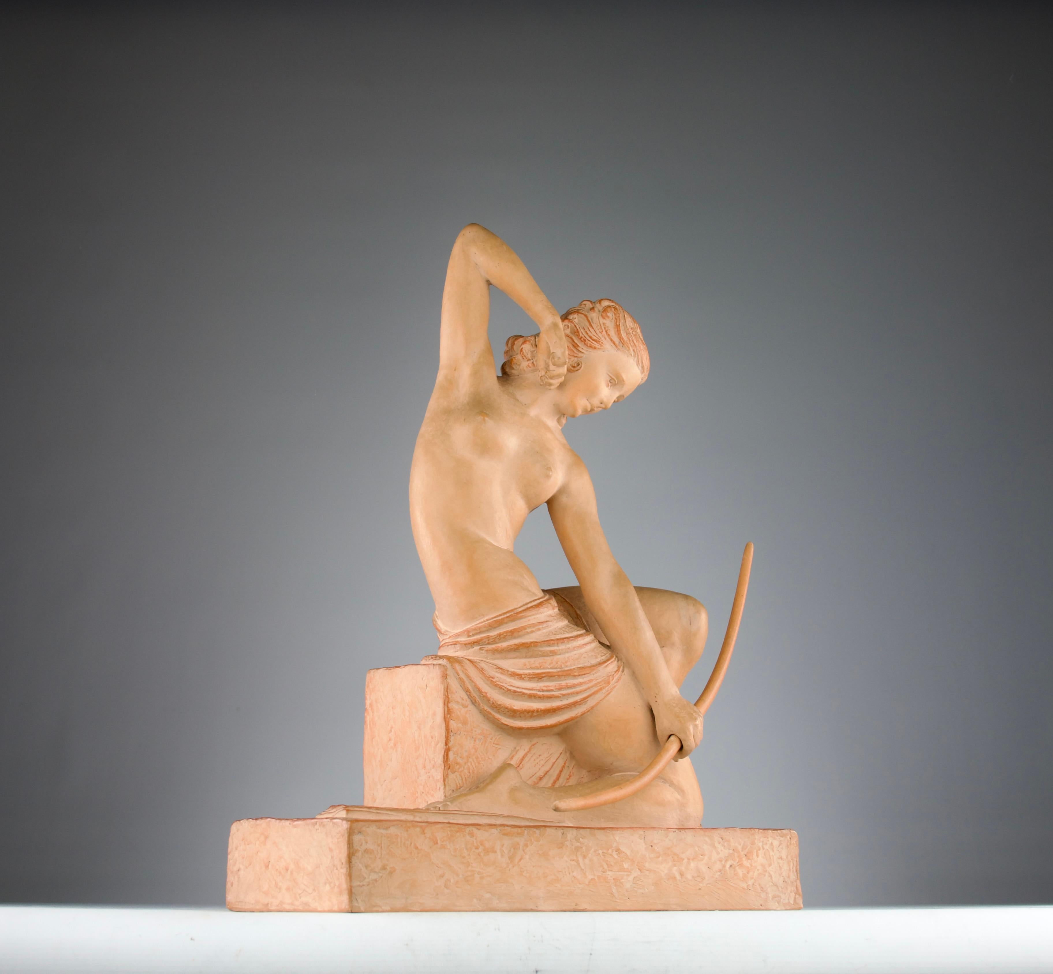 Magnífica y rara escultura de terracota de Deméter Haralamb Chiparus (1886-1947) en colaboración con Reveyrolis Paris Editeur de Diana Cazadora desnuda tensando su arco de madera. Firmado en la terraza por el artista y el editor. 

Excelente