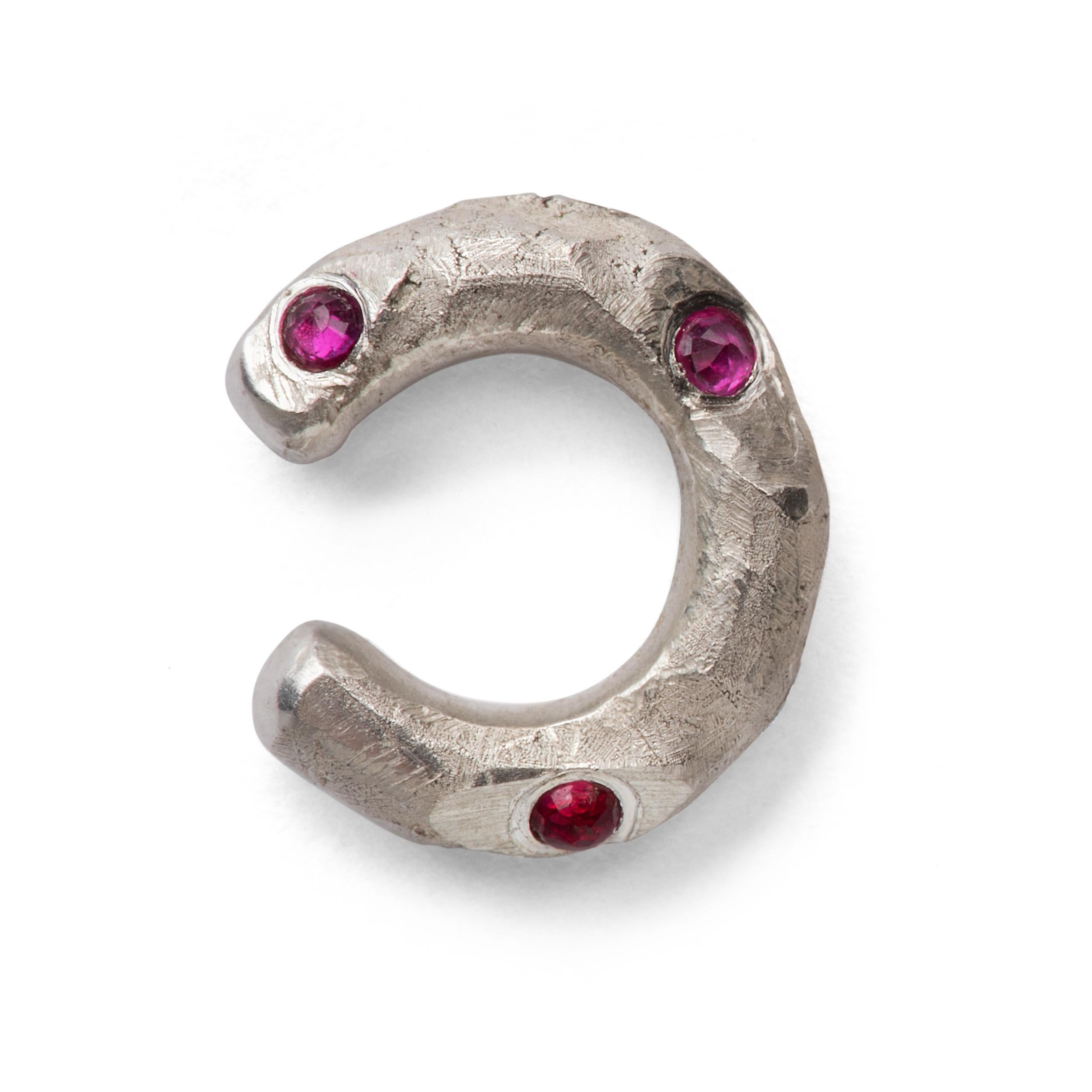 Sterling silver ear cuff 18mm diameter with a high polished interior and textured exterior, studded with inverted brilliant cut 1.5mm rubies. Made from one branch of a silver tree that was constructed in wax and cast, with the buds cut off,