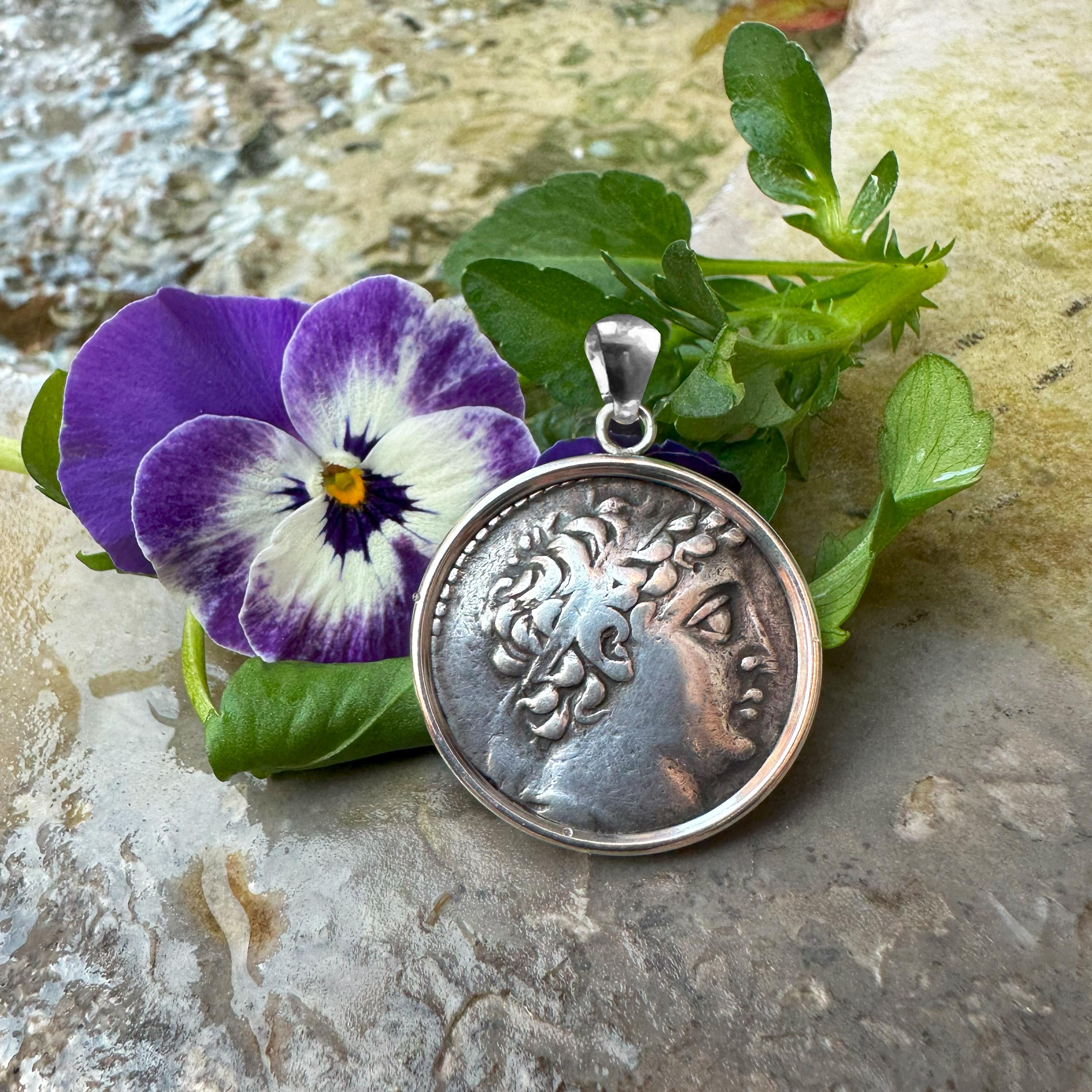 This stunning sterling silver pendant features a genuine greek coin from 145-125 BC, showcasing Demetrios II. The obverse side depicts the noble portrait of Demetrius II, a Hellenistic ruler known for his leadership in the Seleucid Empire. On the