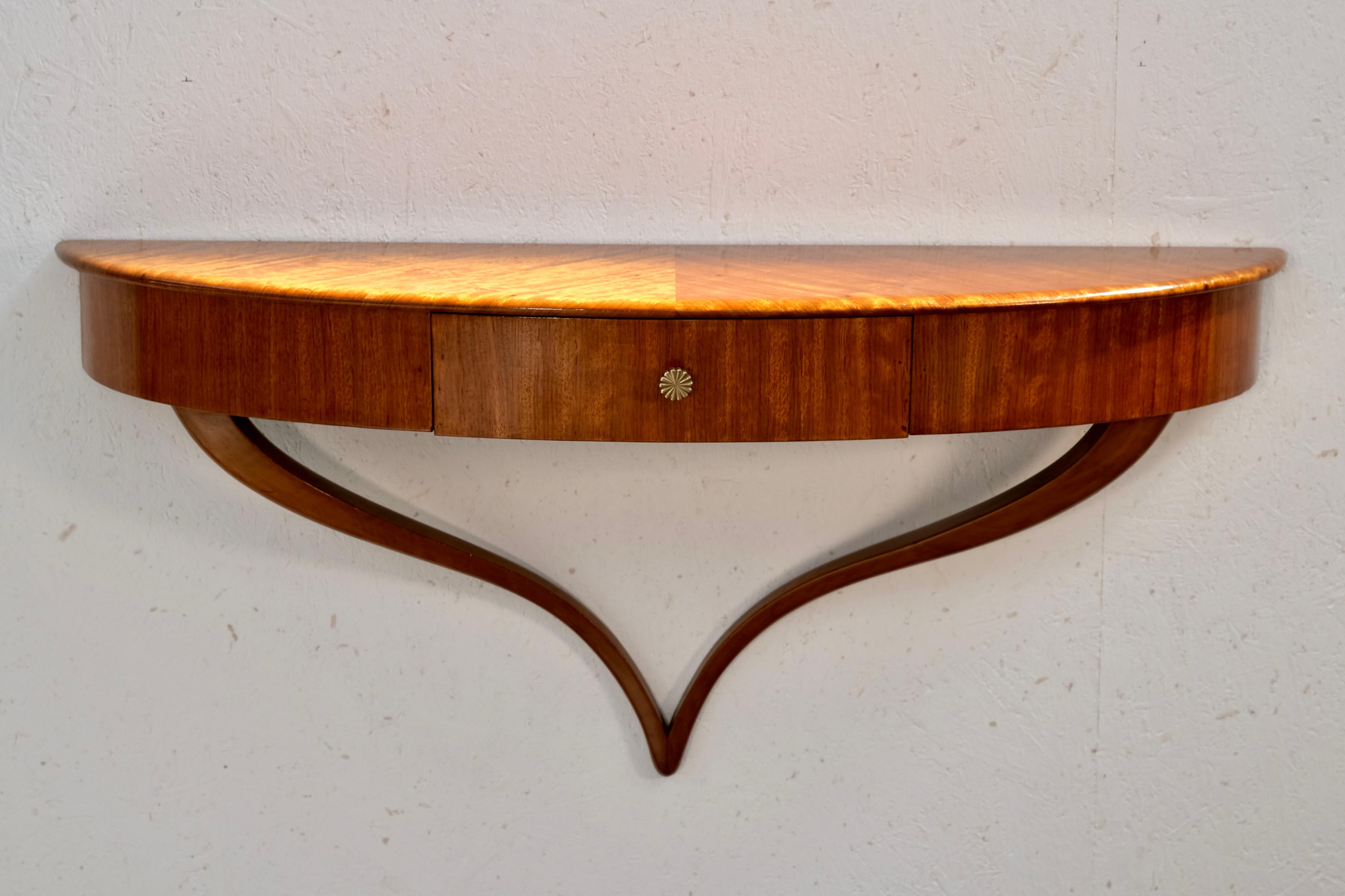 This elegant French Art Deco wall console from the 1930s captivates with its light, sculptural form and refined detailing. Designed in a classic demi-lune (half-moon) shape, it features a richly grained mahogany veneer that shimmers with depth and