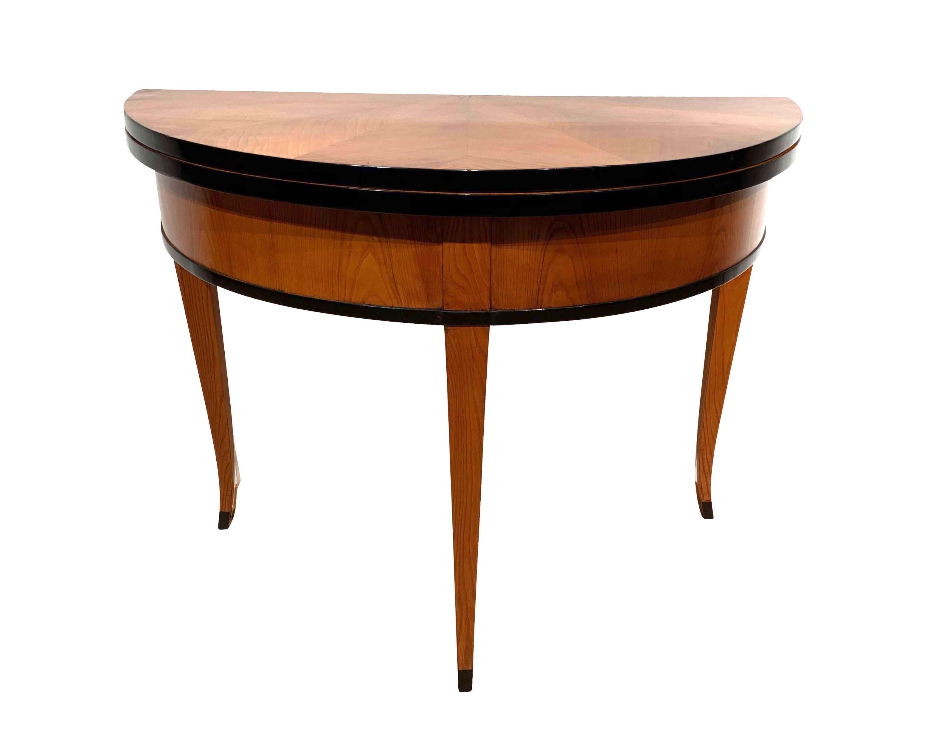 Beautiful demilune fold-out table with star shaped ash veneer.

Foldable on pull-out middle leg. Edge of the plate has been ebonized.
Curved square-pointed legs. Maple inlay on the plate (partly blackened)
Wonderful French polished high-gloss