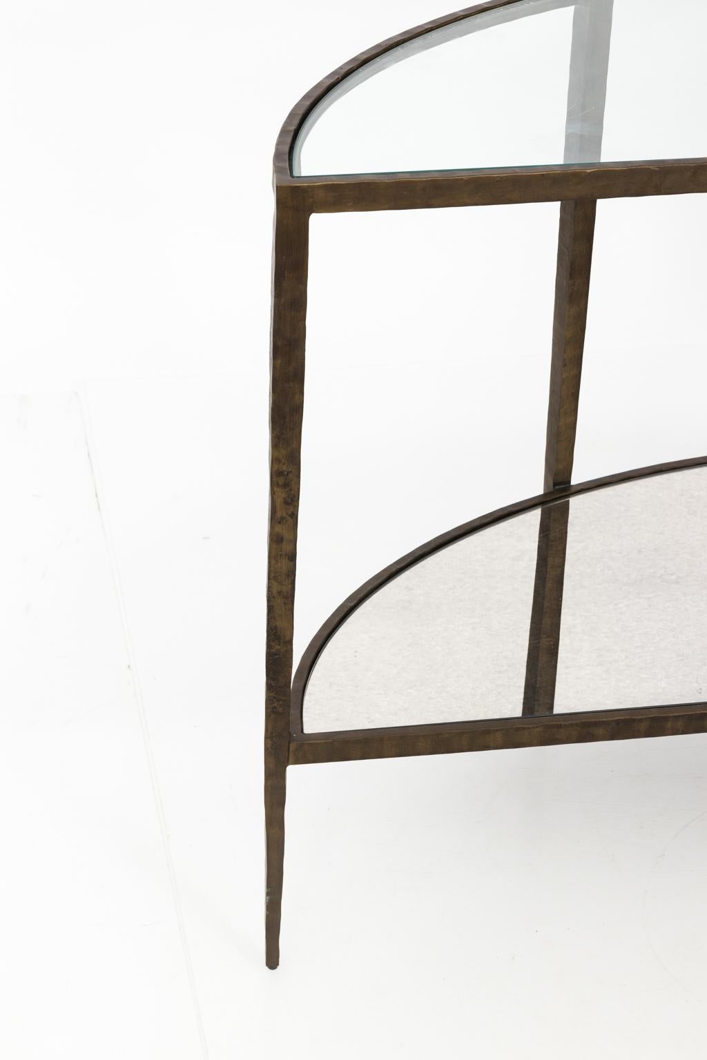 Demilune console with a hammered iron frame in a bronze finish. There is a fitted glass top and a fitted mirrored bottom. Both are removable. Several small scratches to glass.