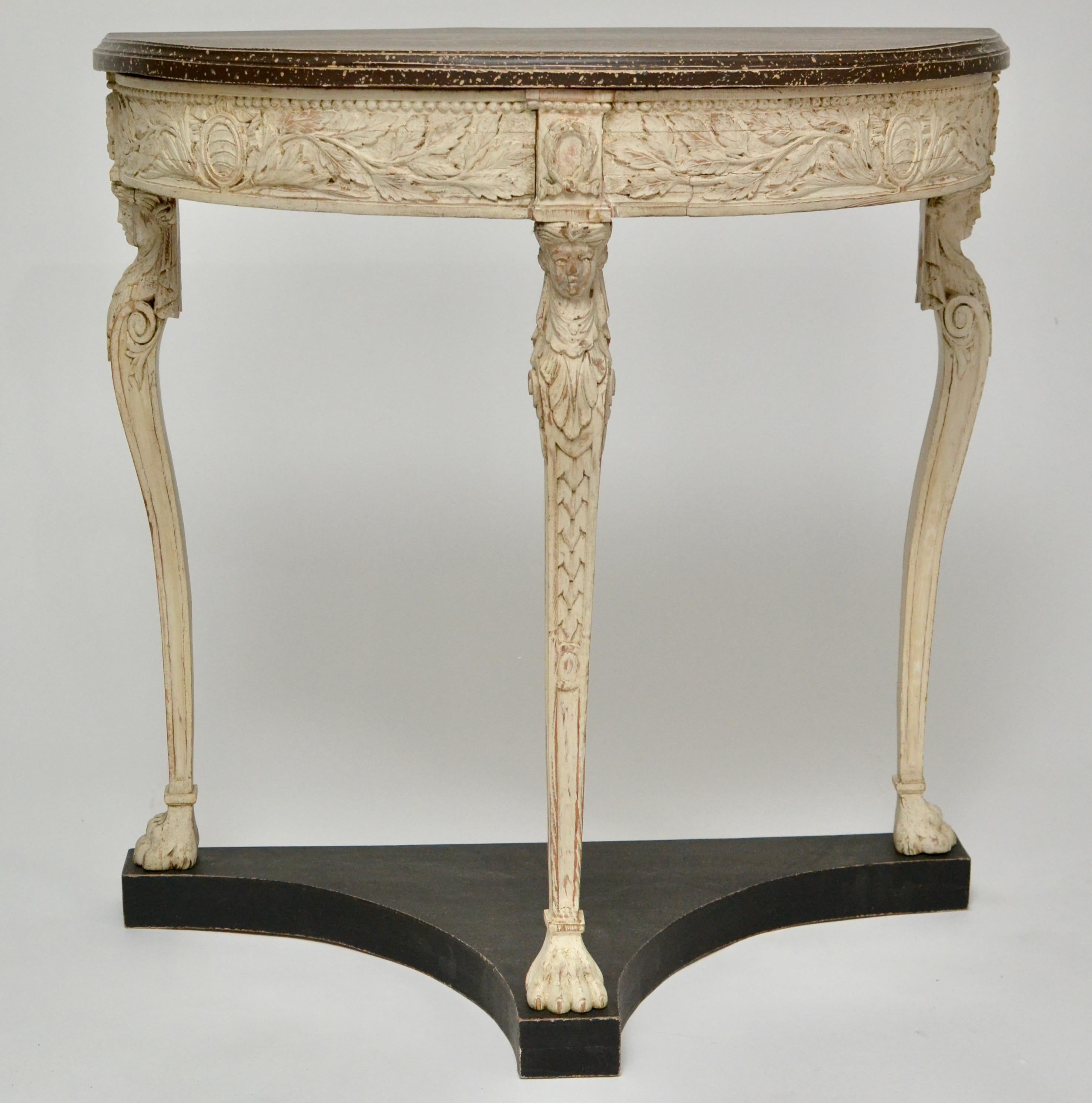 An unusual wood carved and white painted late gustavian demi-lune console table with a faux porphyry painted top. From around 1800. Possibly Swedish.