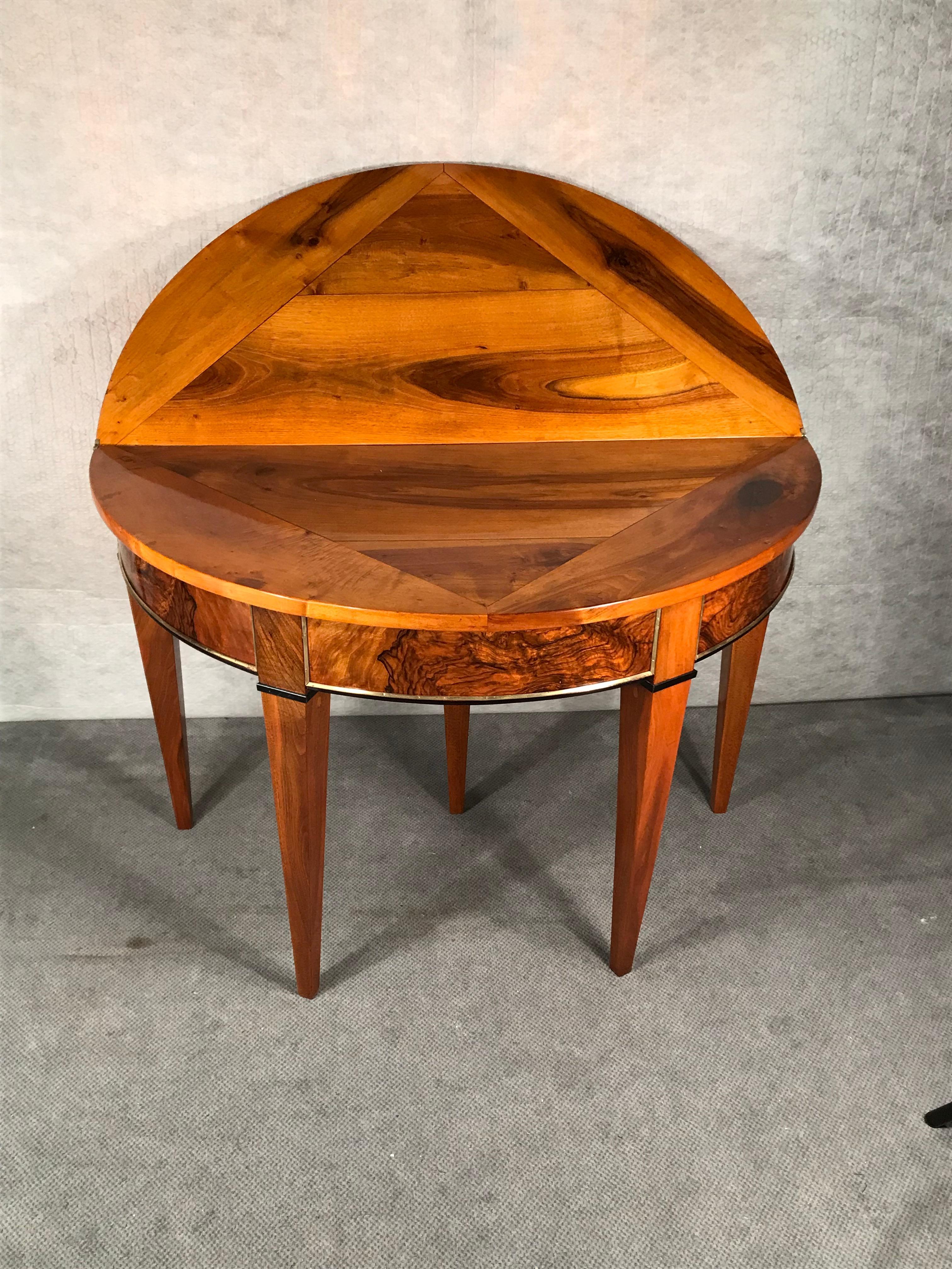 Demilune table, South West Germany 1810. This unique demi-lune table dates back to the beginning of the 19th century. The table has a very pretty walnut veneer pattern on the outside and inside of the top. It comes expertly refinished and is