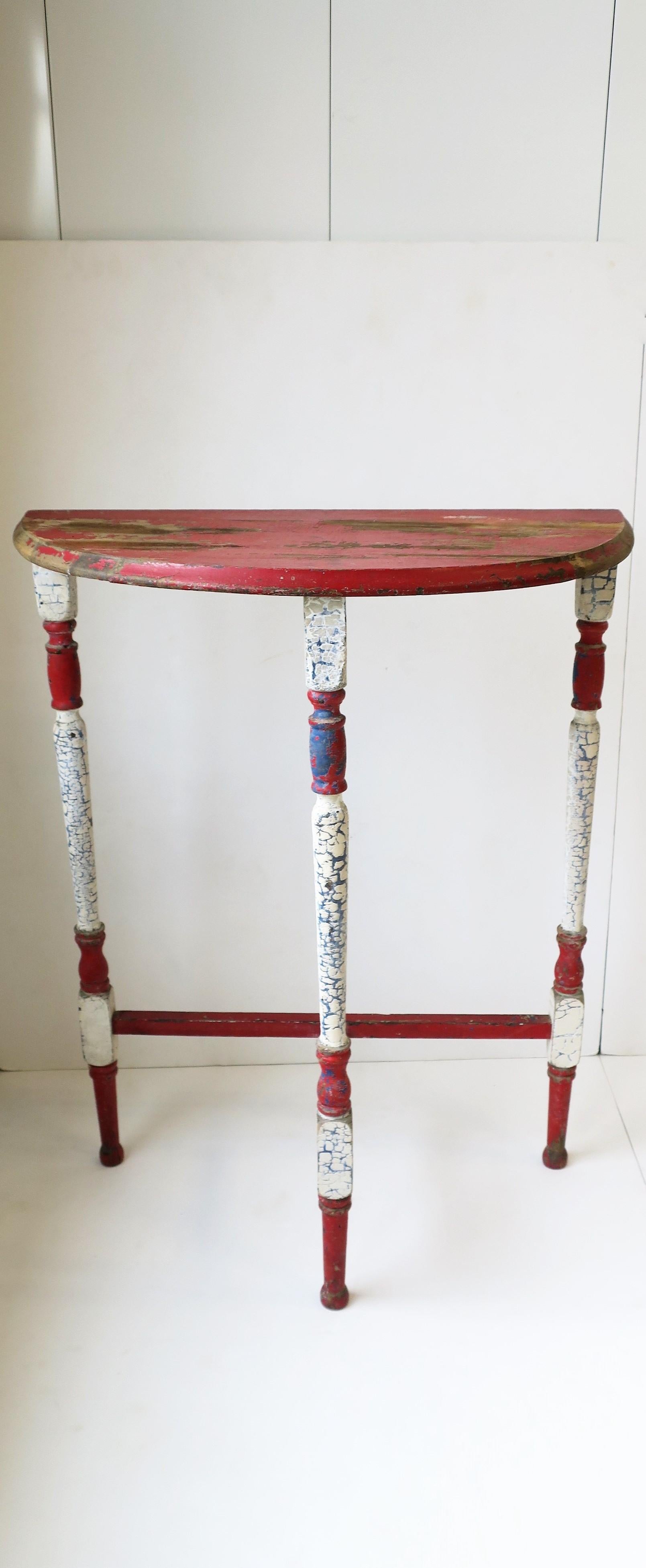 A small demilune or half-moon wood console table in red, white and blue, circa early 20th century, USA. A great piece of Americana in a convenient size. Piece measures: 12