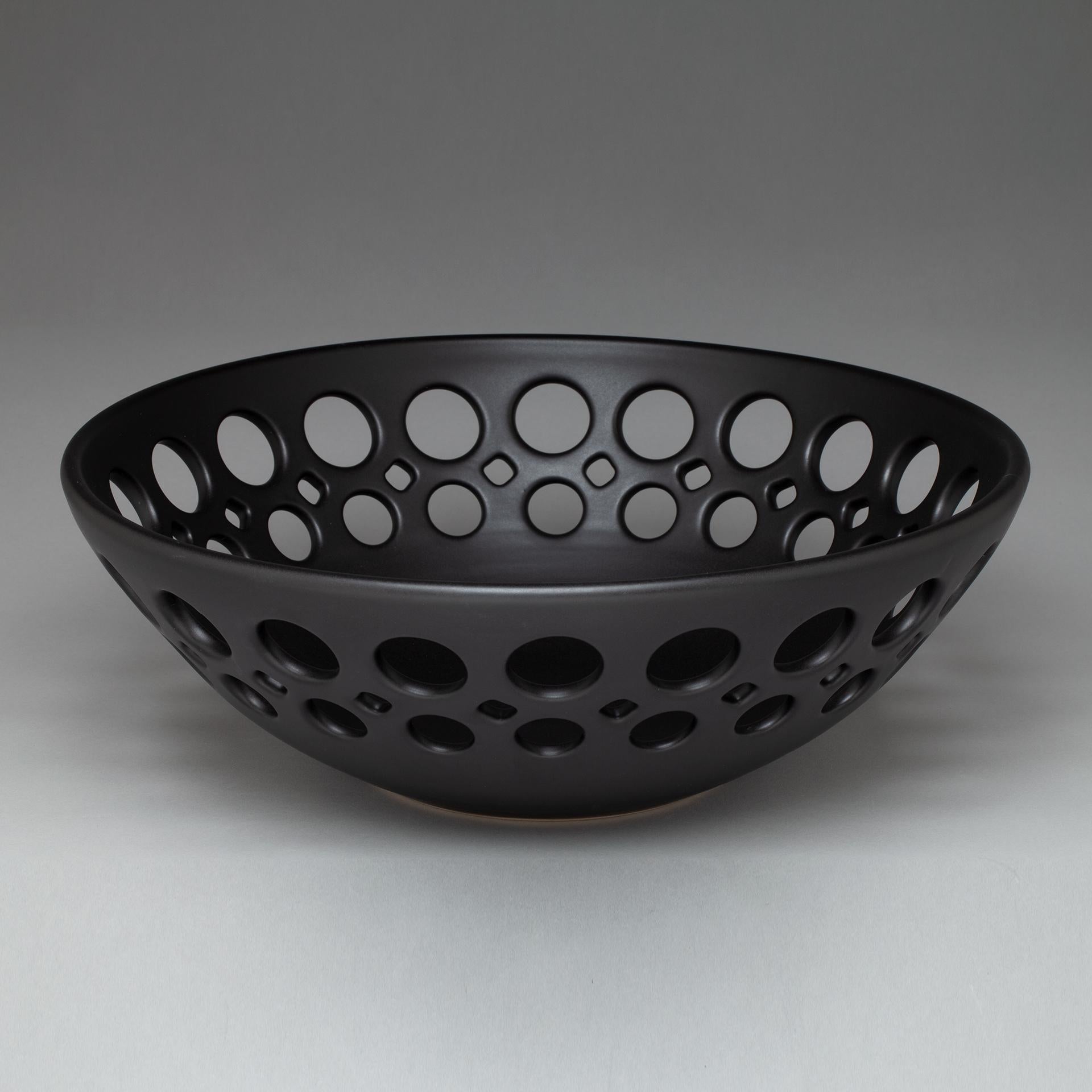 Inspired by Mid-Century Modern design, the pierced collection is wheel thrown and hand pierced stoneware with a satin glaze. Small holes are created when the clay is still wet and then each hole is painstakingly enlarged and smoothed when the clay