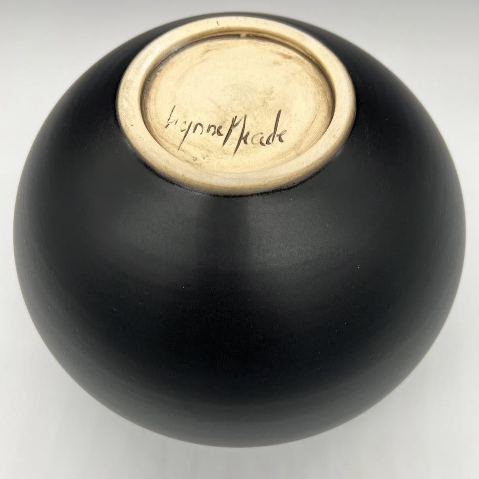 This piece is wheel thrown and hand pierced. When the piece is still wet, small holes are mapped out and pierced. Once the orb is bone dry, each hole is painstakingly enlarged. A black satin glaze is then applied and fired.