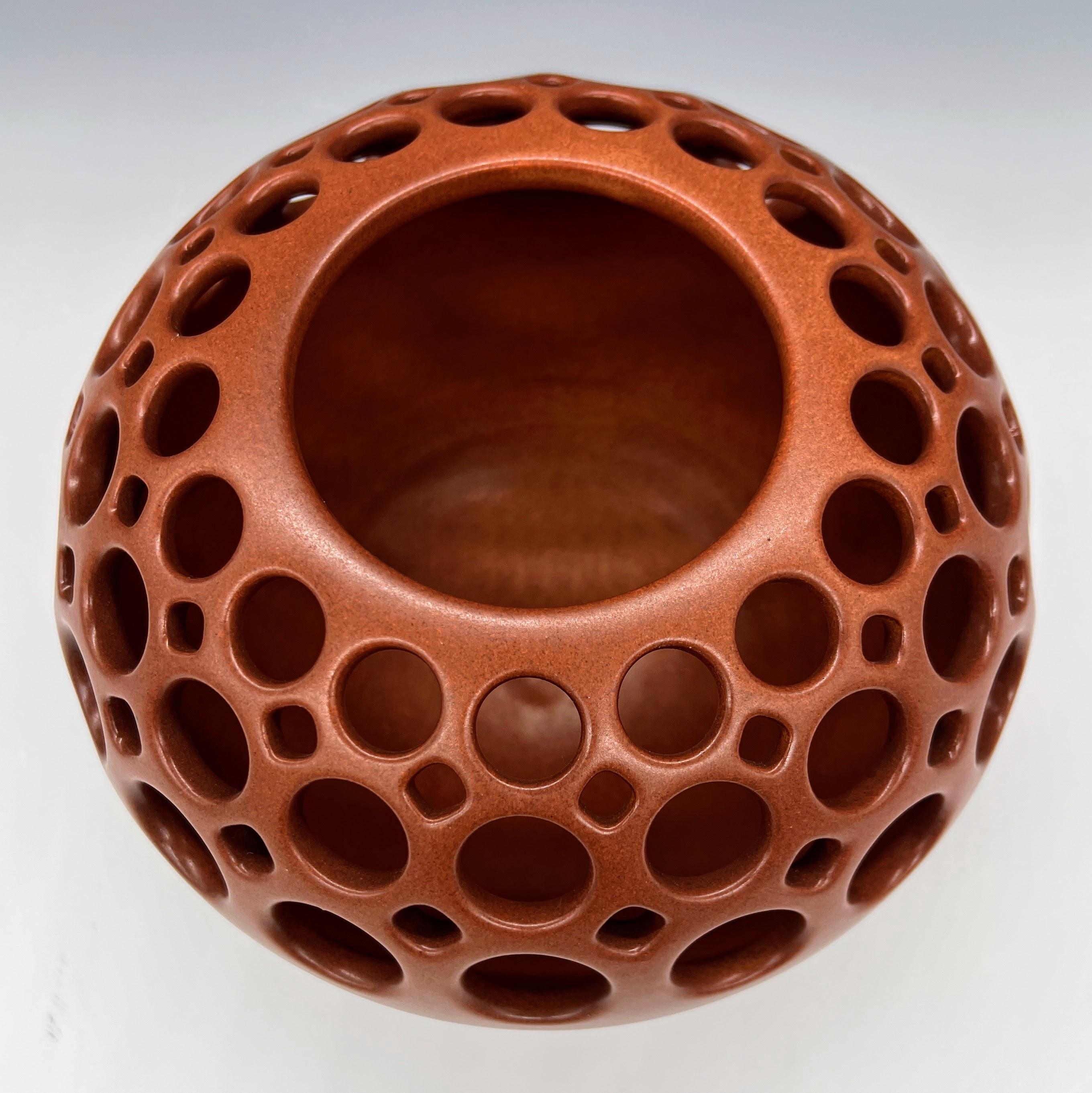 This piece is wheel thrown and hand pierced. When the piece is still wet, small holes are mapped out and pierced. Once the orb is bone dry, each hole is painstakingly enlarged. A burnt sienna satin glaze is then applied and fired. Perfect as a