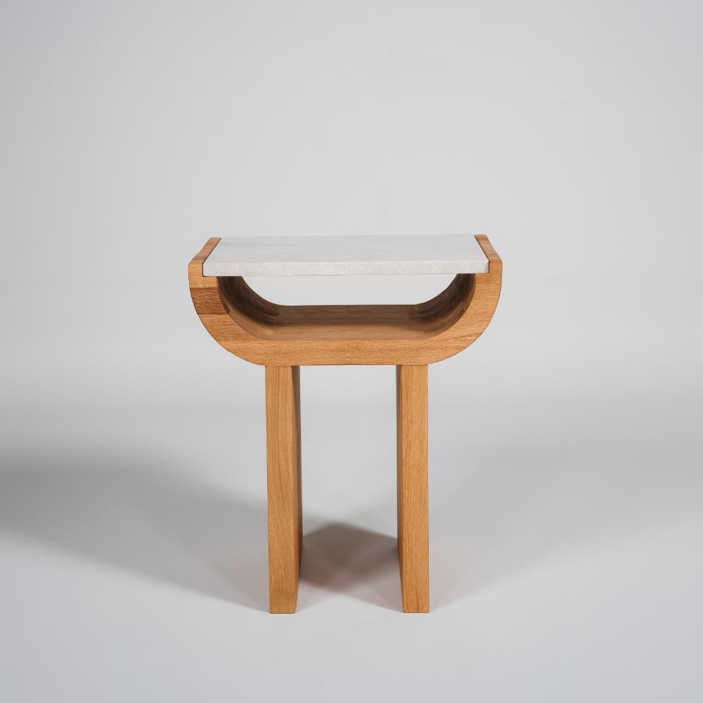 La table d'appoint Demi sera une pièce unique que vous pourrez utiliser aux côtés de vos fauteuils et canapés. Avec son corps en chêne massif et son plateau en marbre, il offre non seulement une apparence élégante, mais aussi une expérience