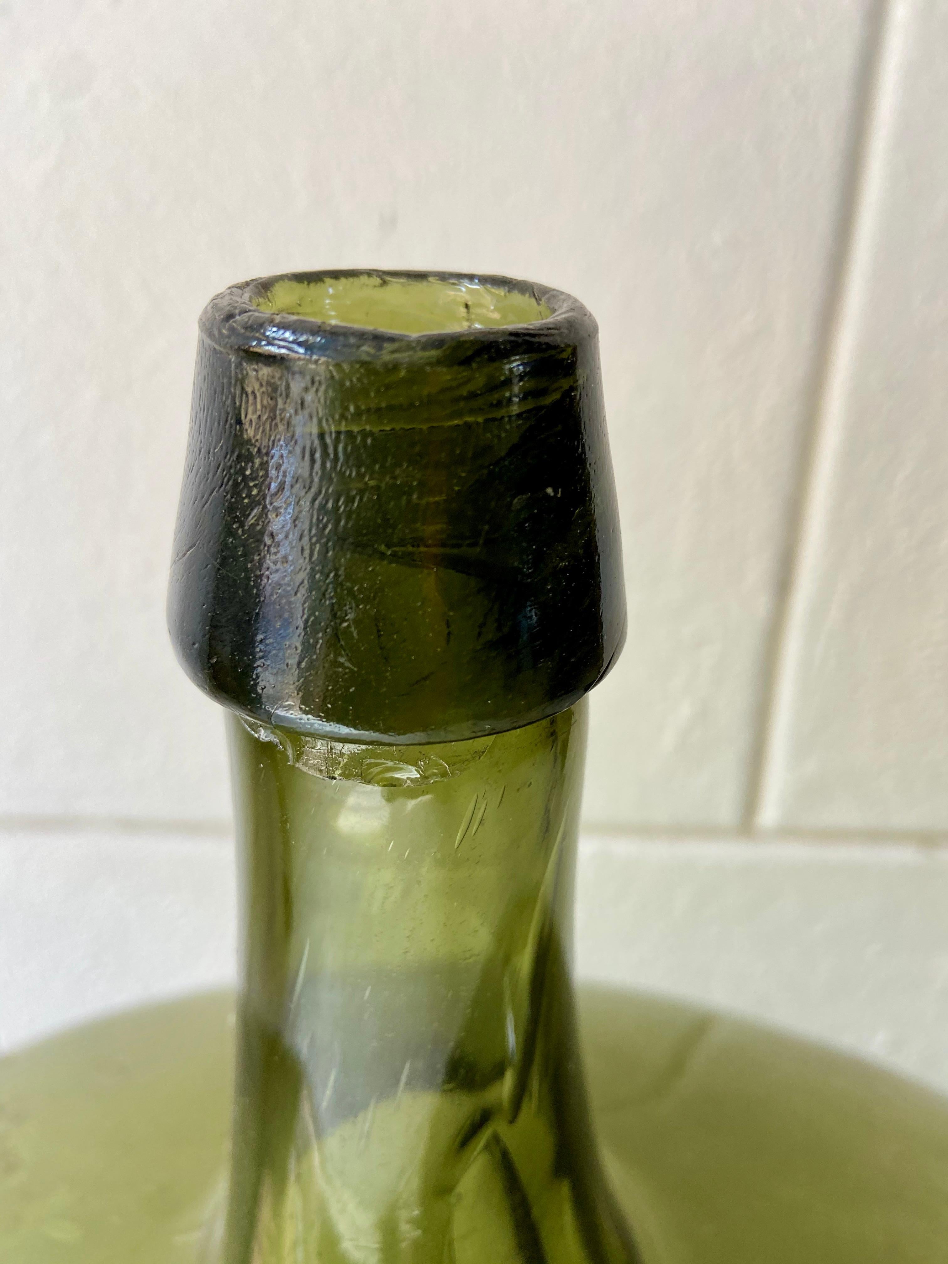 Olive green demijohn bottle from Northern Puebla, Mexico, circa 1920s.