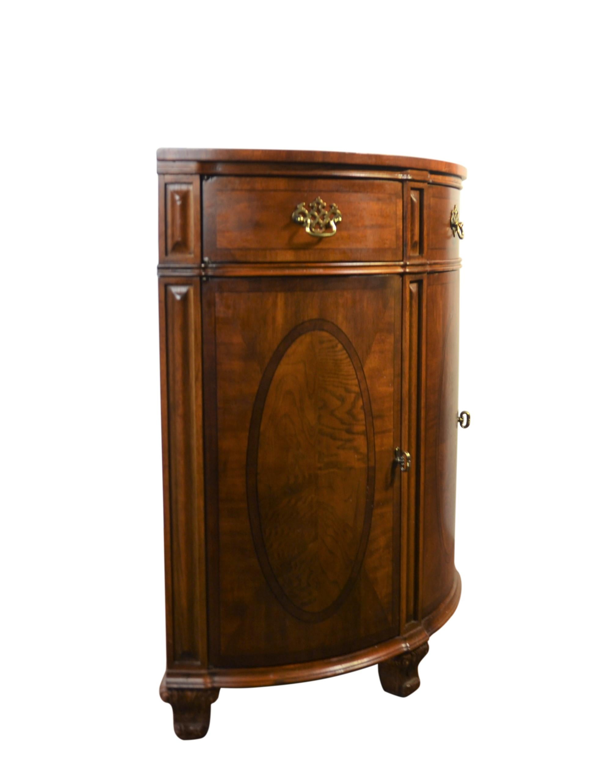 Mahogany demilune console/cabinet. Faux-drawer on top and four doors on bottom for storage. Brass pulls.