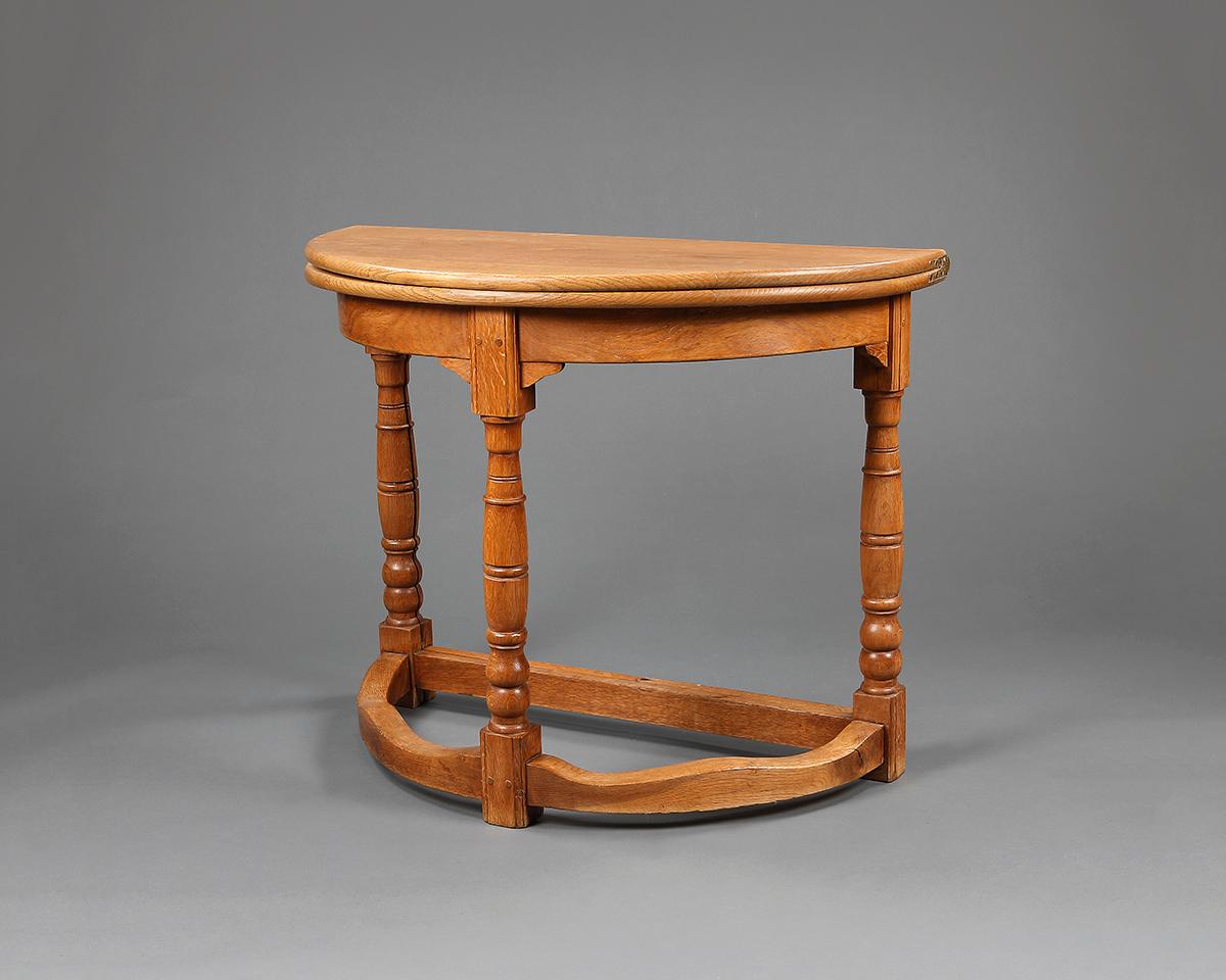 A late 19th century oak demilune side table, with folding top and gate-leg, in the manner of Lorimer,

English, circa 1890.