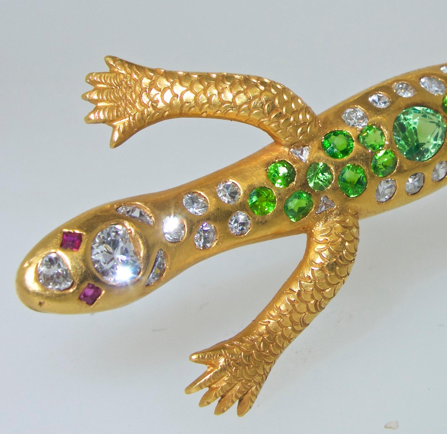 Demontoid garnets from Russia are very rare which makes this brooch quite desirable.  This charming fellow is well made, and over three inches long.  His eyes are fancy cut rubies, the very white diamonds are round and fancy cut, and the 18 bright