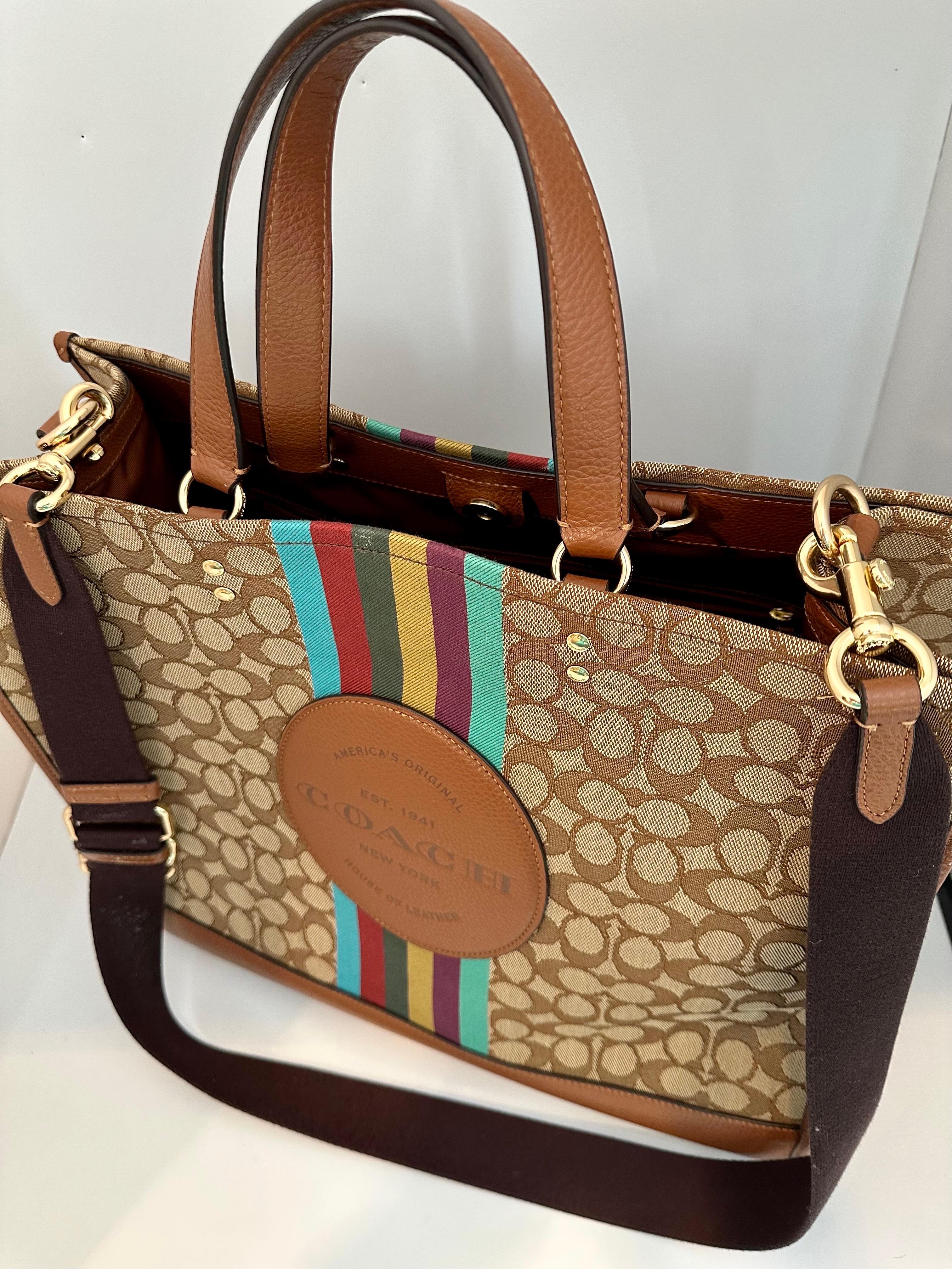 Huge Neverfull by Coach 
Good for traveling 
Signature jacquard and refined pebble leather
Inside zip, cell phone and multifunction pockets
Snap closure, fabric lining
Handles with 6