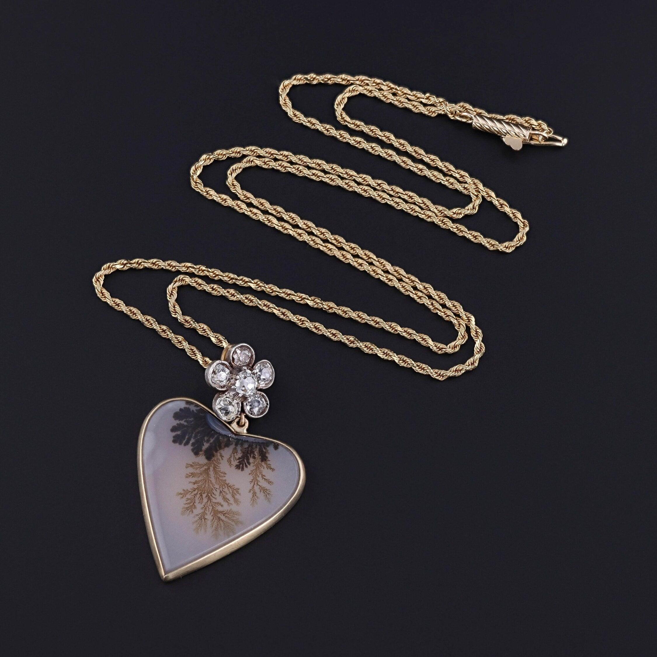 Questa collana presenta un antico fiore di diamante (circa 1890) su un cuore di agata dendritica montato in oro 14k. Il fiore è in argento ricoperto d'oro 14k e presenta 6 diamanti taglio old mine con un peso totale di circa 0,602 carati.

Il