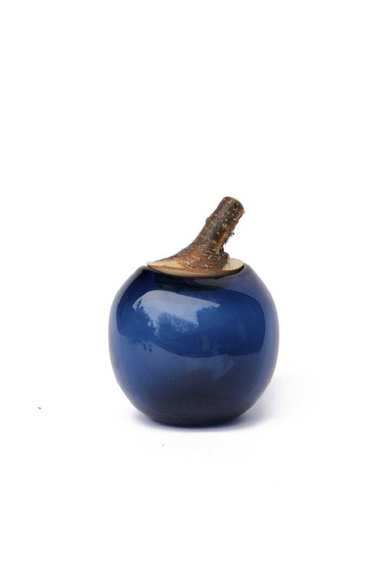 Denim Blue Branch bowl, Pia Wüstenberg.
Dimensions: D 16-18 x H 20.
Materials: glass, wood.
Available in other colors.

A playful jar, with a lid made from a branch stub following the curvature of the glass. Branch Bowls are blown without a