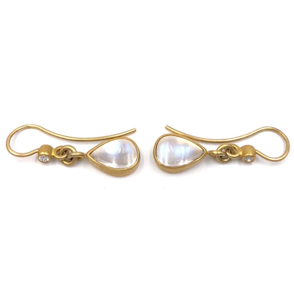 Drop Earrings by Denise Betesh hand-fabricated in signature matte-finished 22k yellow gold featuring a matched pair of glowing pear-shaped blue moonstone cabochons totaling 5.17 carats and accented with 0.10 total carats of round brilliant-cut white
