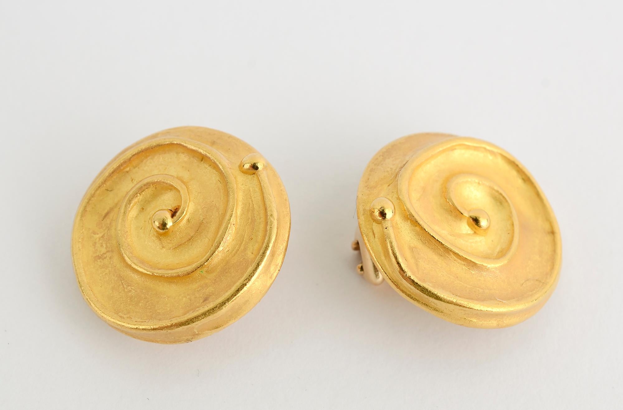 Stylish earrings by Denise Roberge that look simultaneously ancient and modern. An irregular glossy gold coil sits upon a matte finish disc. The back, which would only be seen by the wearer, has yet another texture. Clip backs can be converted to