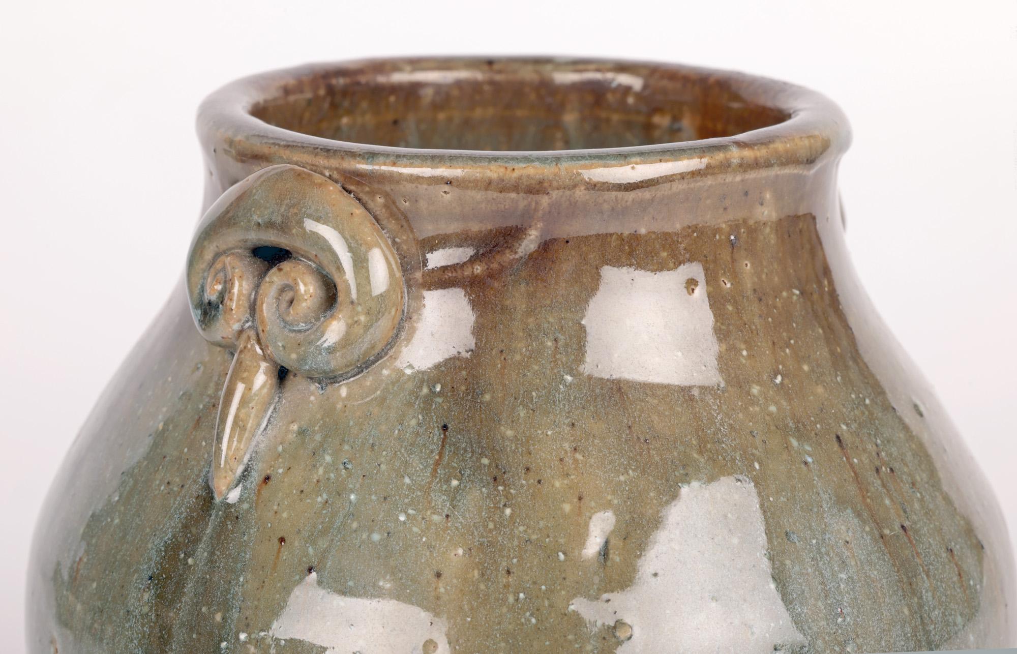 Un élégant et inhabituel vase à deux anses en poterie du studio Oxshott Pottery, réalisé par la célèbre potière Denise Wren (australienne, 1891-1979) et datant probablement d'environ 1950. Ce vase de fabrication artisanale repose sur une base plate