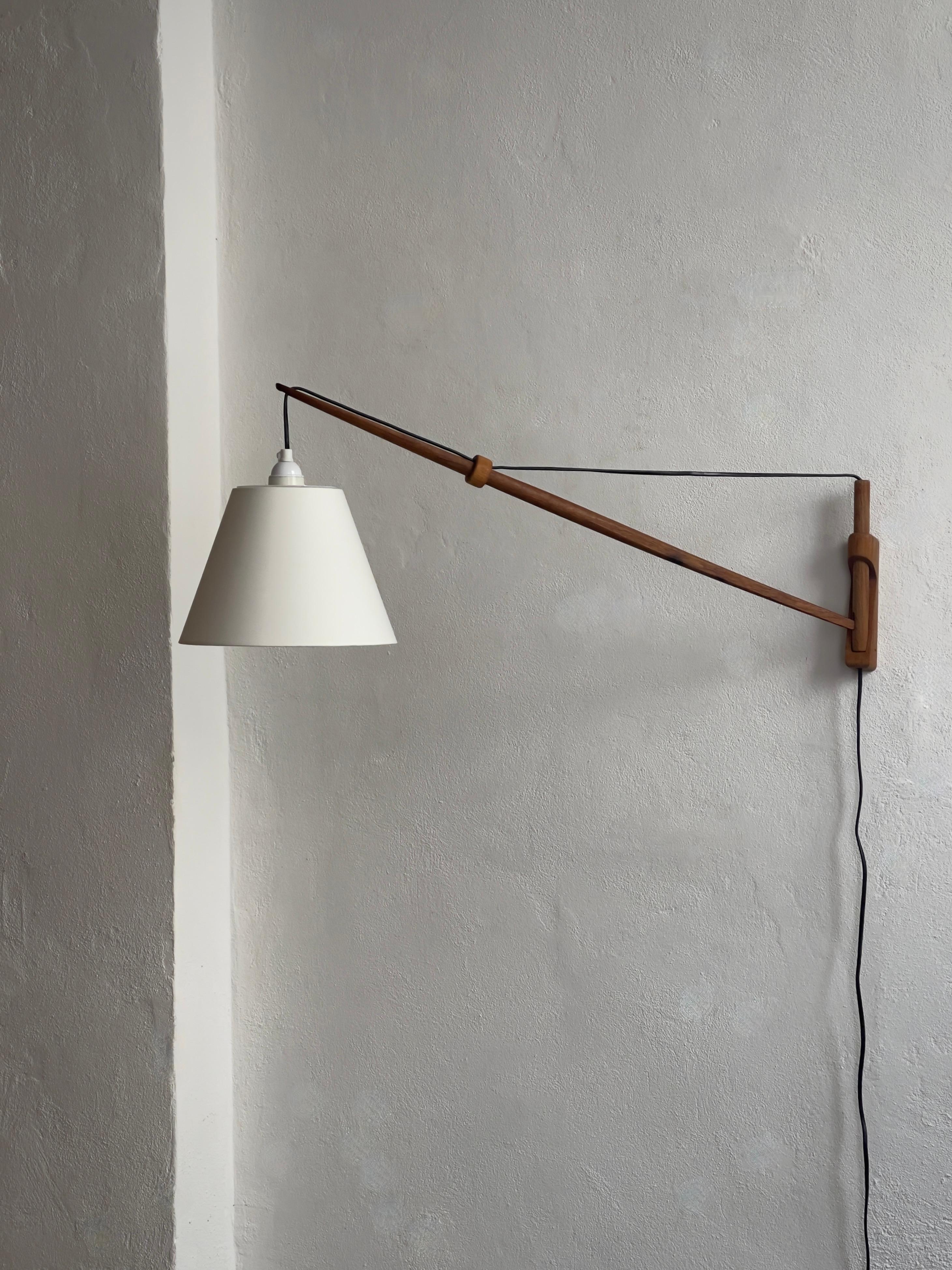 An elegant danish modern wall lamp / pendant. Adjustable to both sides and elevatable. Crafted from solid patinated oak, this wall lamp embodies the movement's penchant for organic materials. Oak's warmth and unique grain patterns give it a timeless