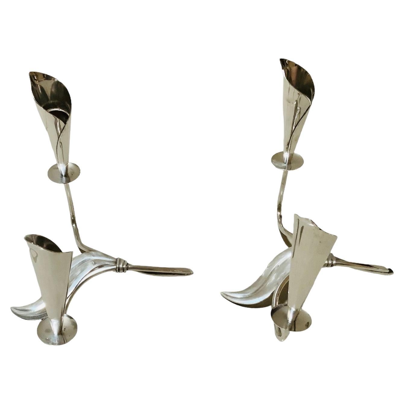 This is a Pair of Silver Plate Candle holders by Hans Jensen. It depicts a pair of silver plate double candle holders shaped as two Calla Lily flowers  branches joined together with a long leaf in the center. Both of them are hallmarked Denmark and