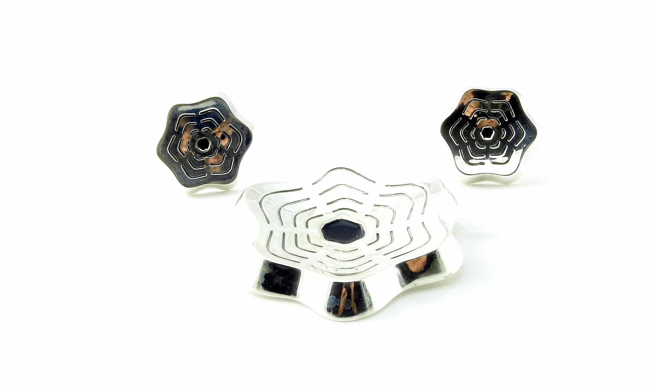 Vintage sterling silver modernist design flower pin and earrings set with black enamel centers, designed by Karen Strand for A. Dragsted of Denmark. The clips on the earrings are 14K yellow gold.

Karen Strand was a Danish jewelry designer known for
