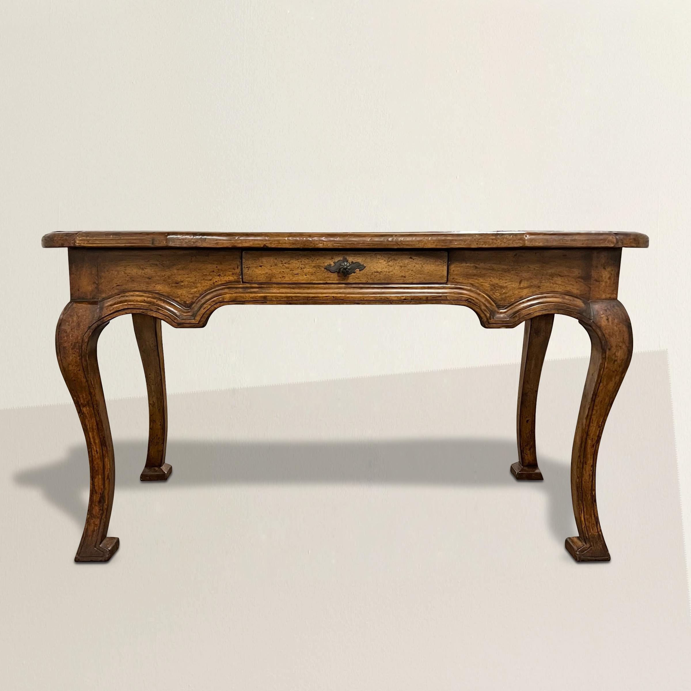 A 21st-century American desk by the renowned high-end furniture maker Dennis & Leen. Inspired by French provincial design, the hand-hewn walnut top with rounded corners and gracefully curved cabriole legs exude a timeless elegance. A single drawer