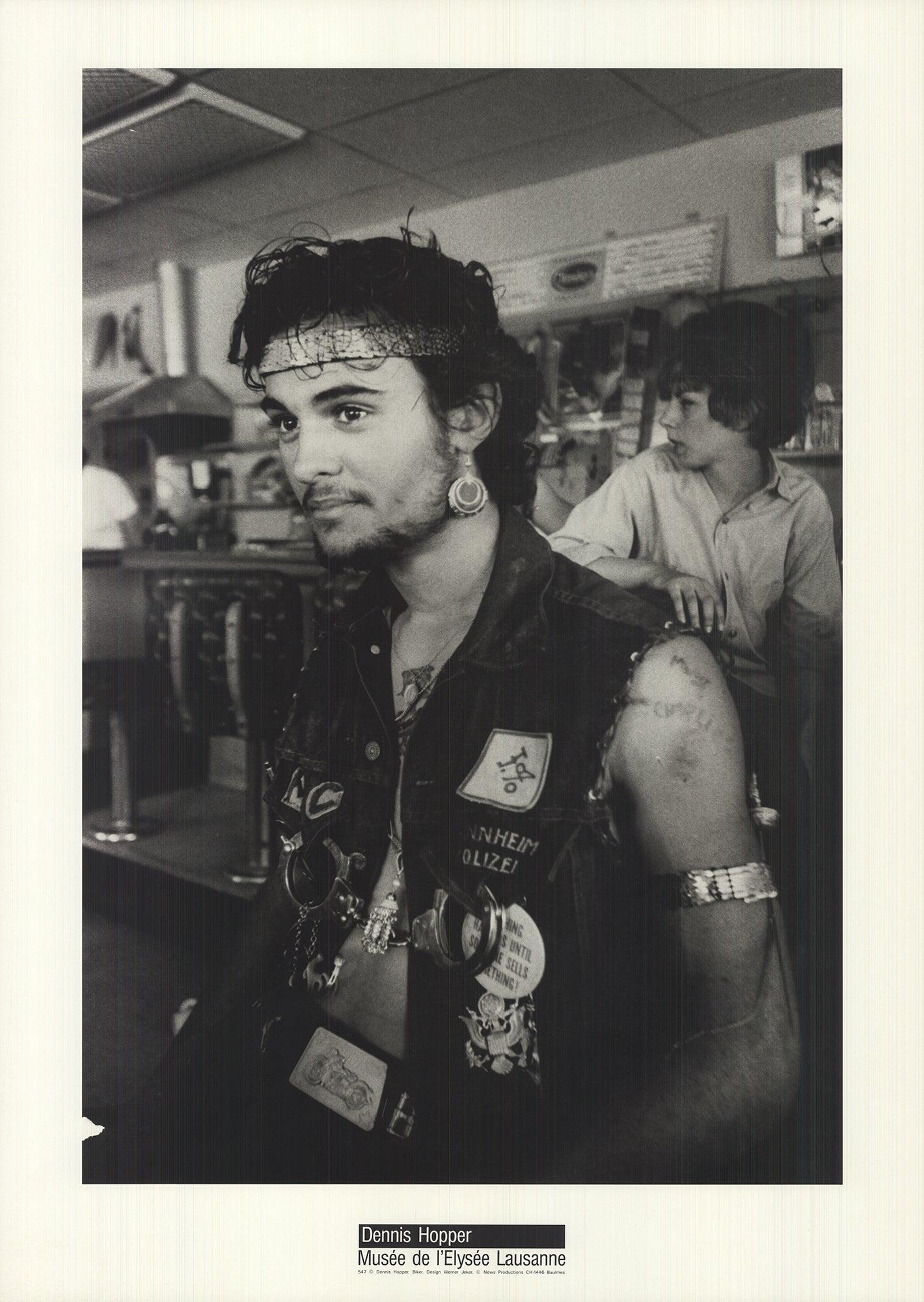 In der Reproduktion des Fotos "Biker" erkennen wir den unverwechselbaren fotografischen Stil von Dennis Hopper, der sich durch seine Unbefangenheit und Unbebildertheit auszeichnet. Dieses Bild verkörpert Momente der Spontaneität und Authentizität,