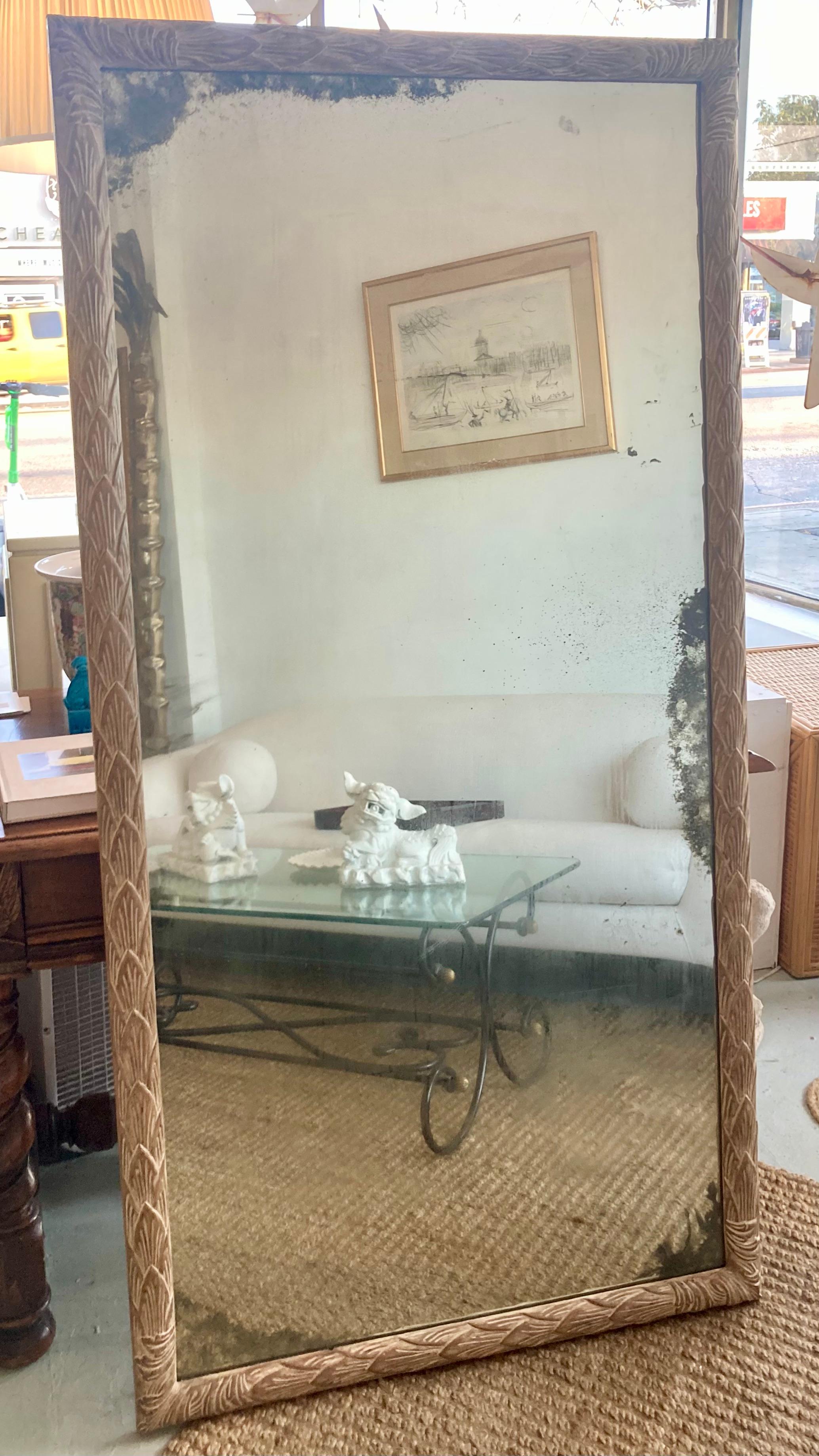 Cadre à feuilles d'acanthe sculpté à la main par Dennis & Leen, avec finition d'origine. De magnifiques détails de miroir vieillis dans un motif irrégulier sur le miroir ajoutent au design et au caractère. Fait amusant : il provient de la succession