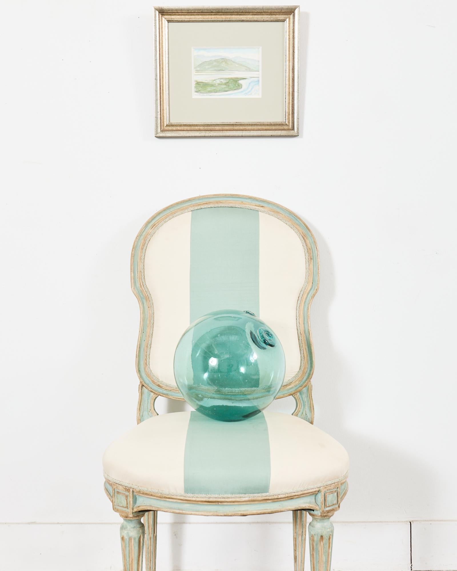 Gorgeous distressed dining chair made in the neoclassical French Louis XVI taste by Dennis & Leen Hollywood, CA. The Louis XVI side chair features an intentionally aged painted patina in a robin's egg green or verdigris as Dennis & Leen call them.