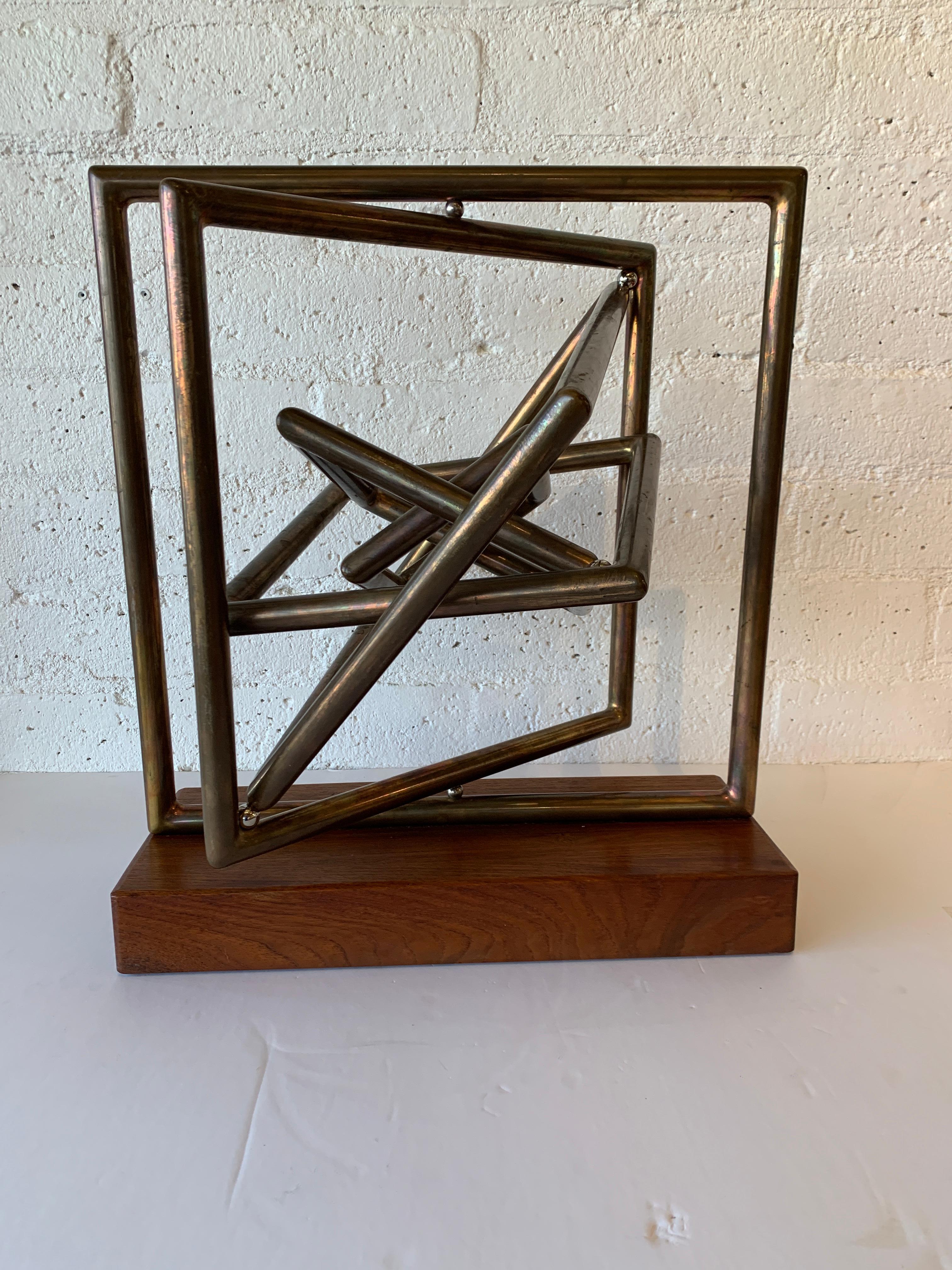 A wonderful large kinetic sculpture by the noted artist Dennis Stewart. Crafted out of copper and steel on a wood base. Lovely patina. Signed on on arm. Overall good age appropriate condition with wear and tarnish to copper and marks to base, mostly