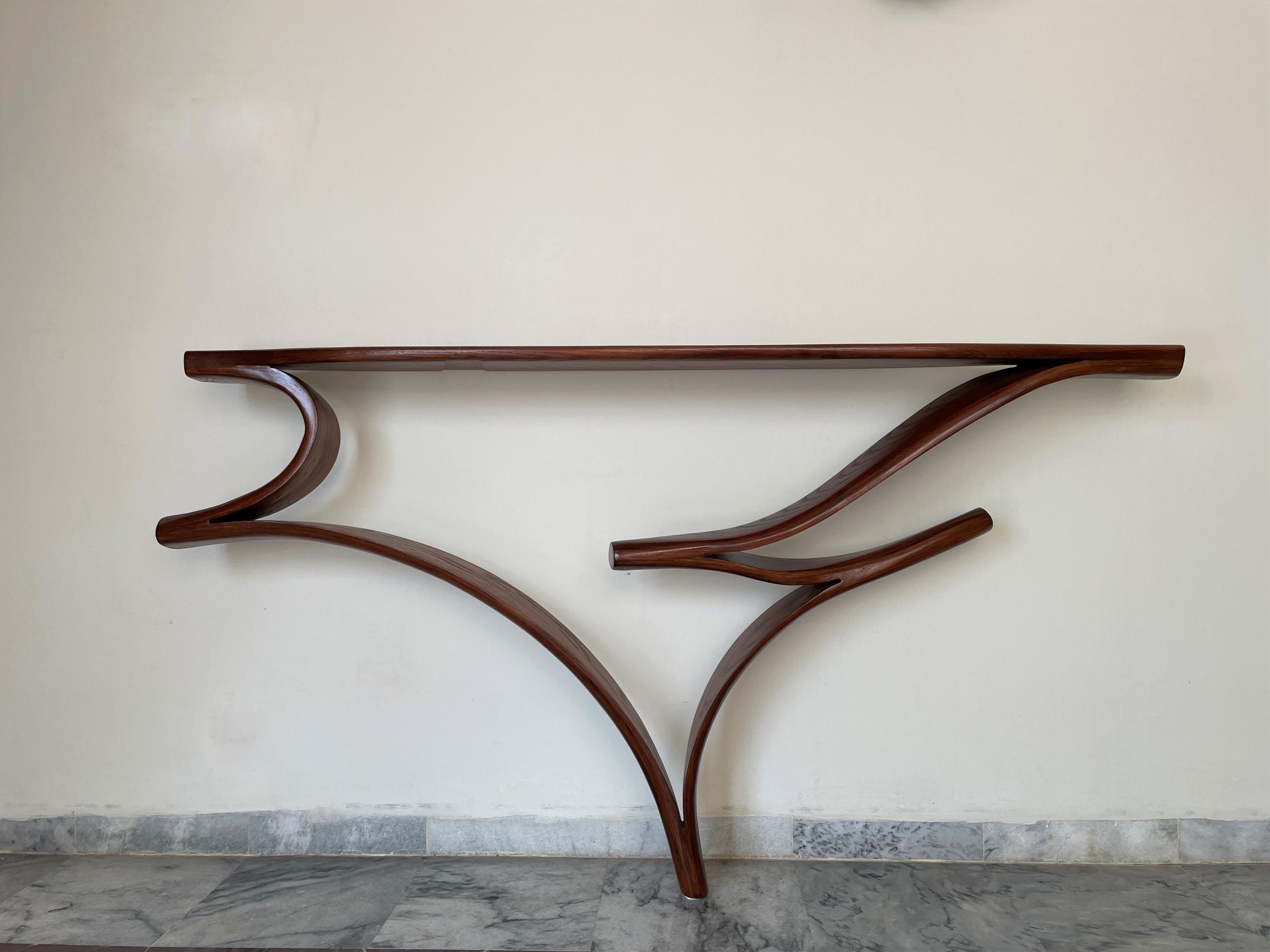 The console has a free-form design; the wood bends and curves with beautiful flows to create the design. The handcrafted details on the piece such as the curves, varying thickness of the wood and twists give the piece its organic flows. The piece