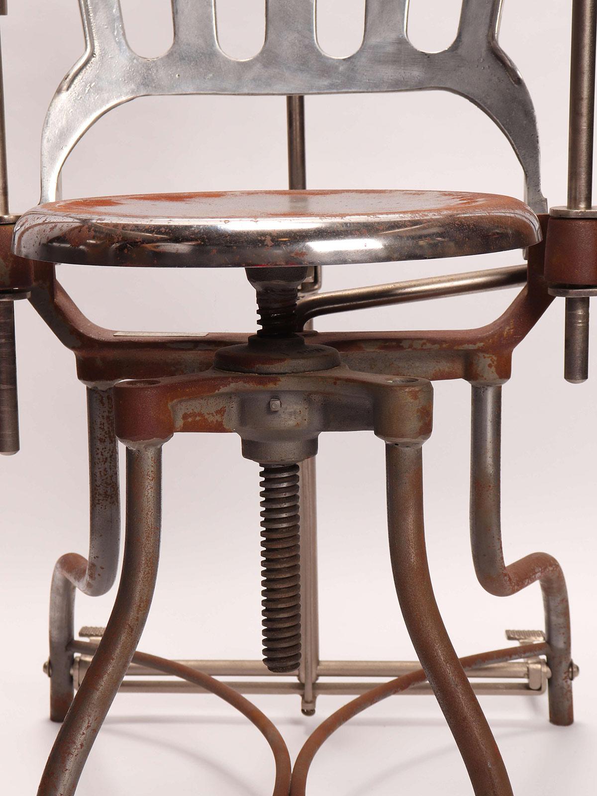A stainless steel dentist’s armchair with a lamp. A reclining backrest, adjustable armrests, and adjustable headrest. Produced from A.S. Aloe Company, St. Louis, MO USA, circa 1920.