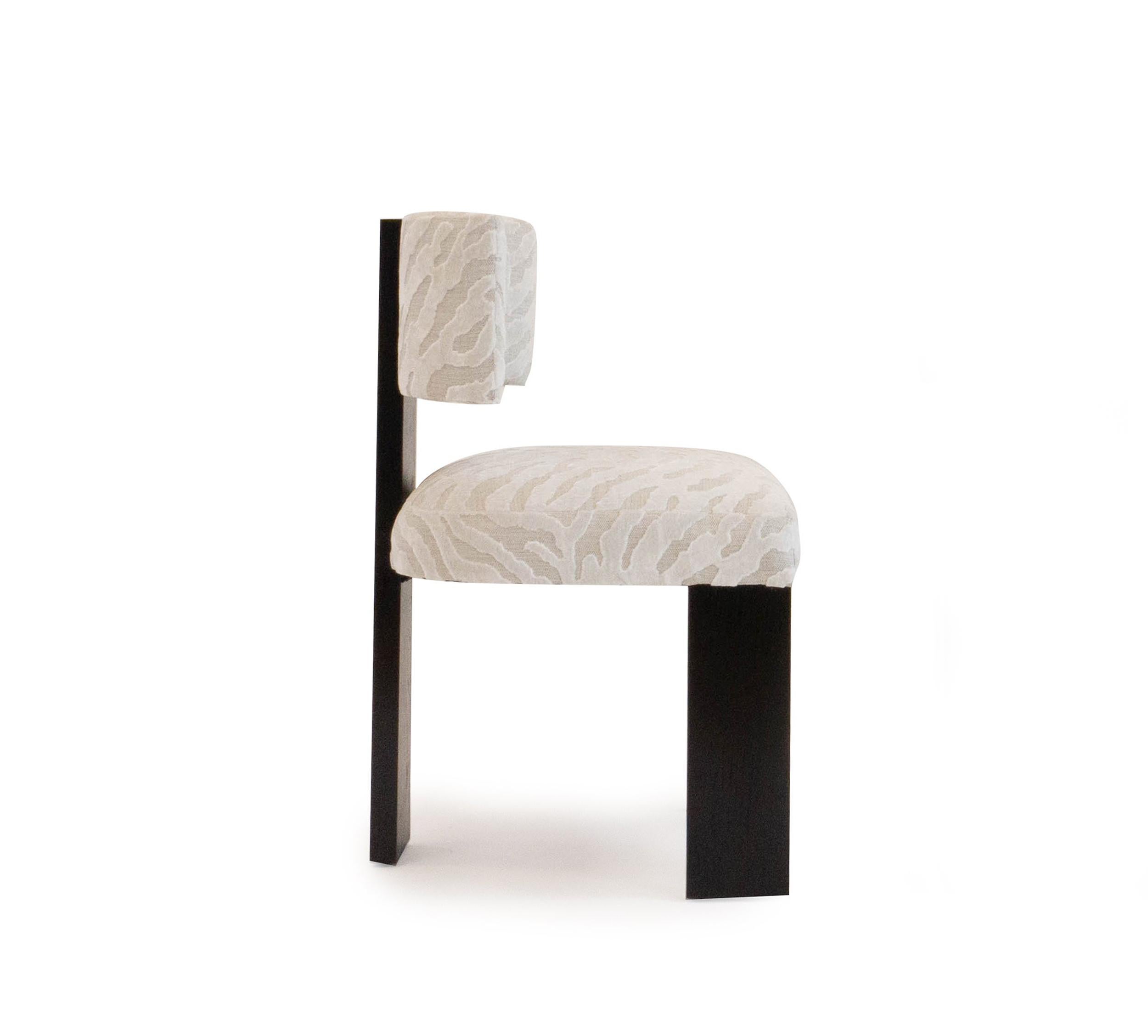Notre chaise de salle à manger Marangoni est une confortable chaise de salle à manger moderne avec un cadre en chêne blanc, finition ébène, présentée dans un velours coupé Romo. Personnalisable sur demande. Fabriqué dans notre atelier du