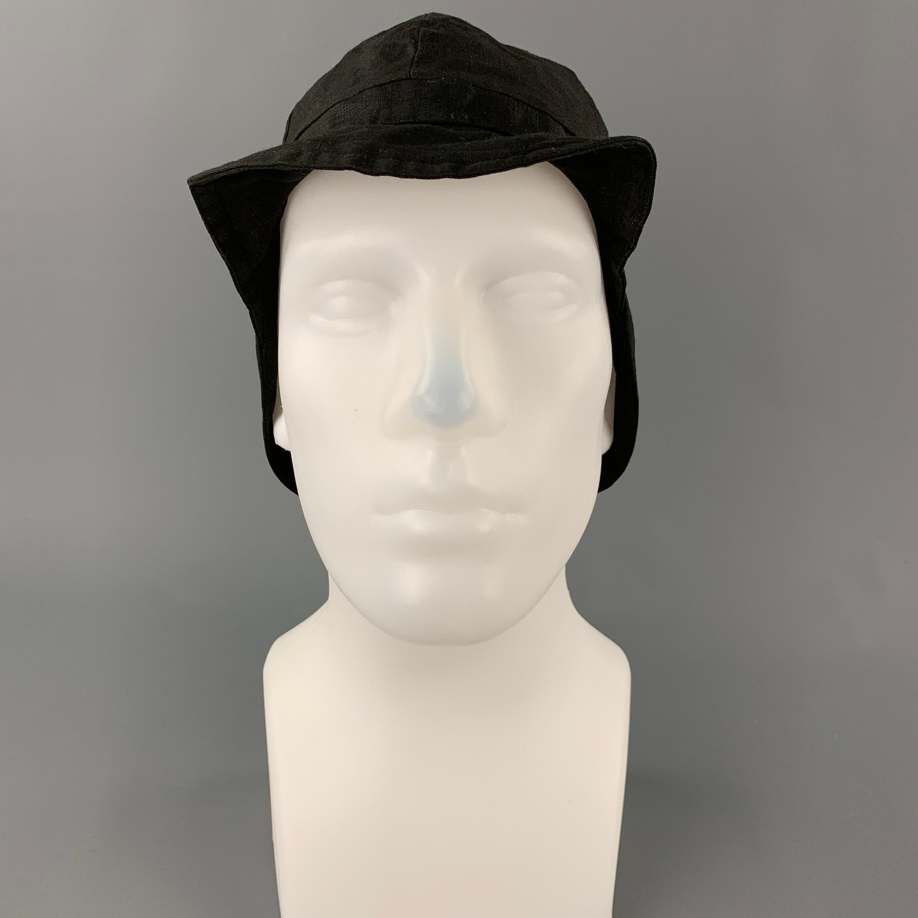 DER ANTAGONIST hat comes in a black linen featuring side flaps, front brim, and a small elastic detail. Made in Germany.

Very Good Pre-Owned Condition.
Marked: 2

Measurements:

Opening: 16 in.
Brim: 2 in.
Height: 6 in. 
