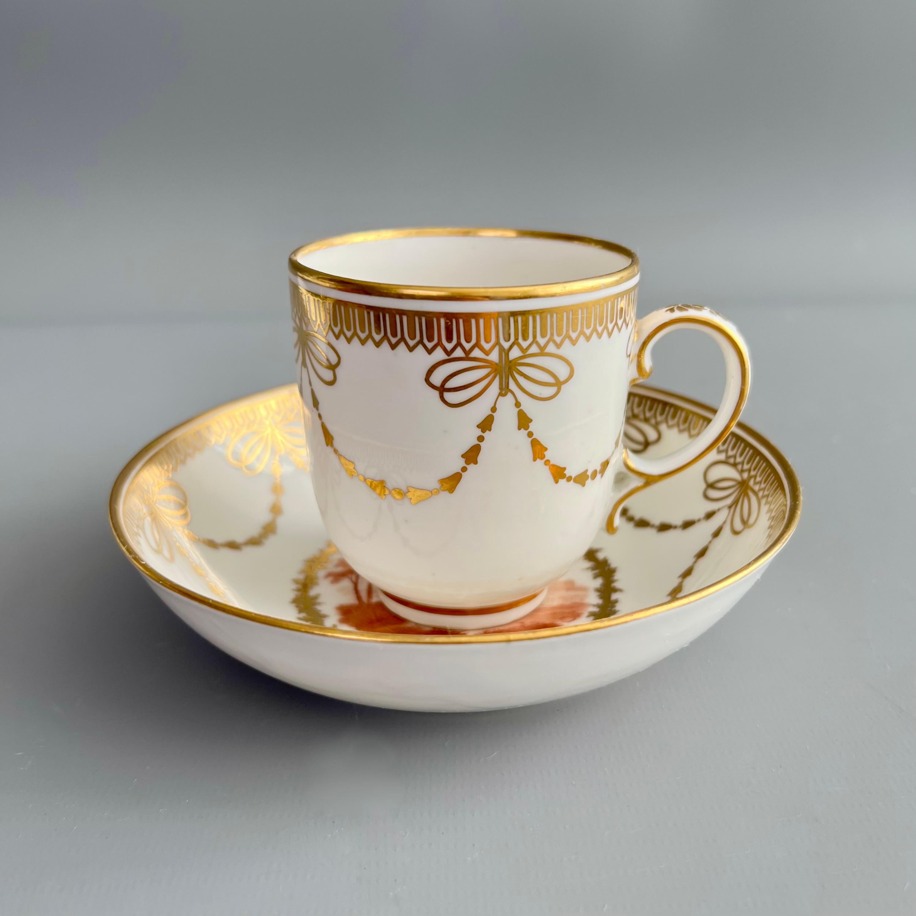 Se trata de una taza y un platillo de café muy raros e impresionantes, fabricados por Derby hacia 1785. El conjunto tiene un fondo blanco con elegantes dorados, y dos impresionantes pequeños paisajes pintados por Zachariah Boreman.
 
La fábrica de