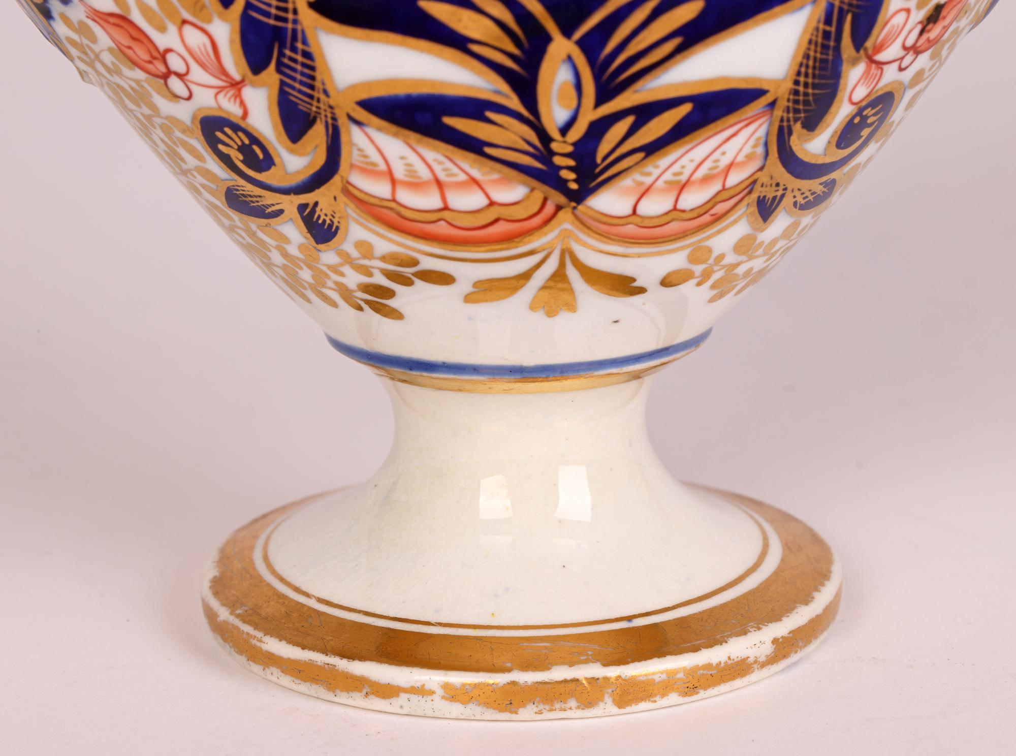 A very fine, rare and unusual antique English Derby partners porcelain inkwell and quill pen holder decorated in the Imari pattern and dating from the early 19th century. The pen and inkwell stands on a narrow round pedestal domed foot with a narrow