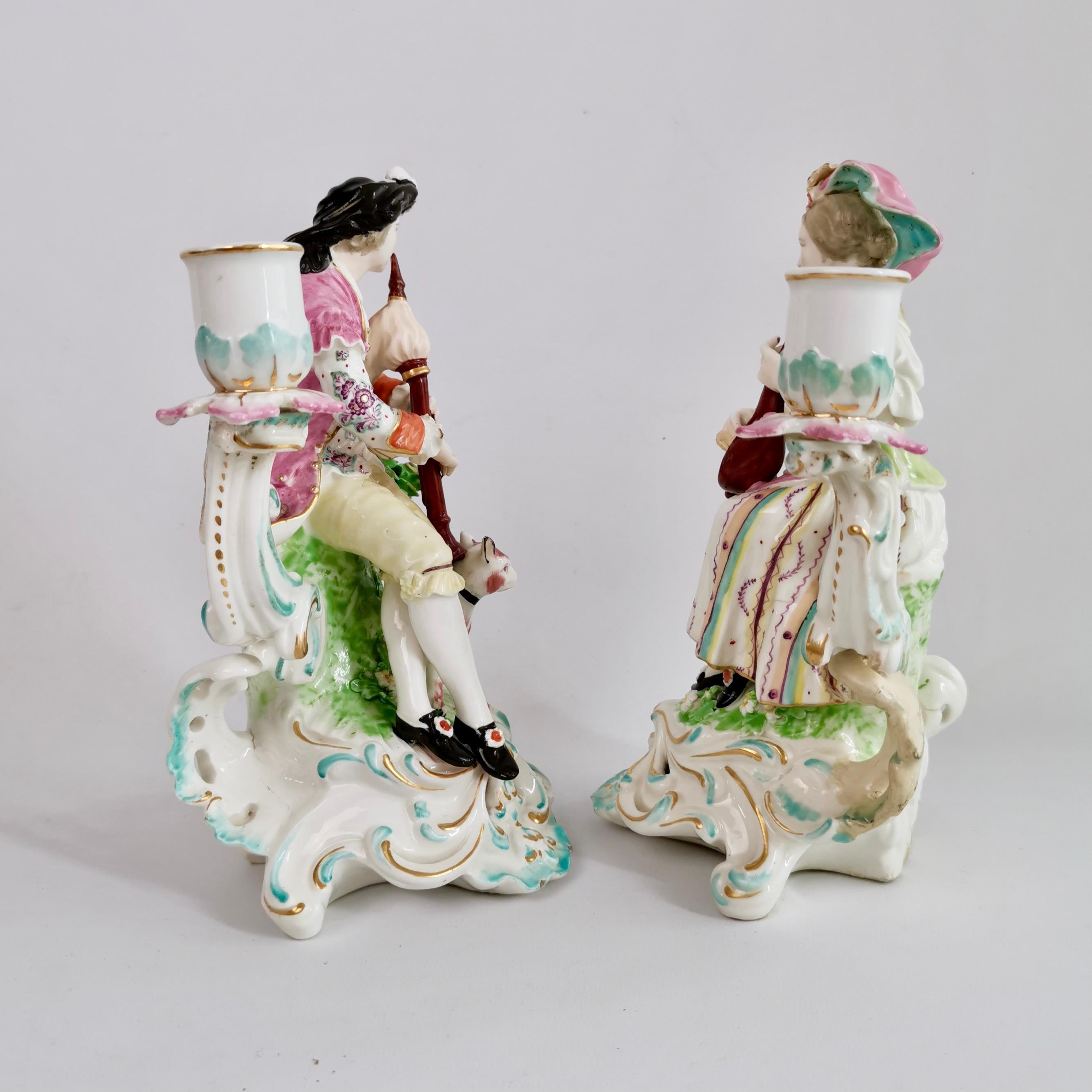 Il s'agit d'une magnifique paire de bougeoirs en porcelaine de Derby représentant un joueur de cornemuse et une dame au luth, fabriqués entre 1759 et 1769, époque du rococo. Cette paire est l'une des célèbres paires de figurines de Derby et cette
