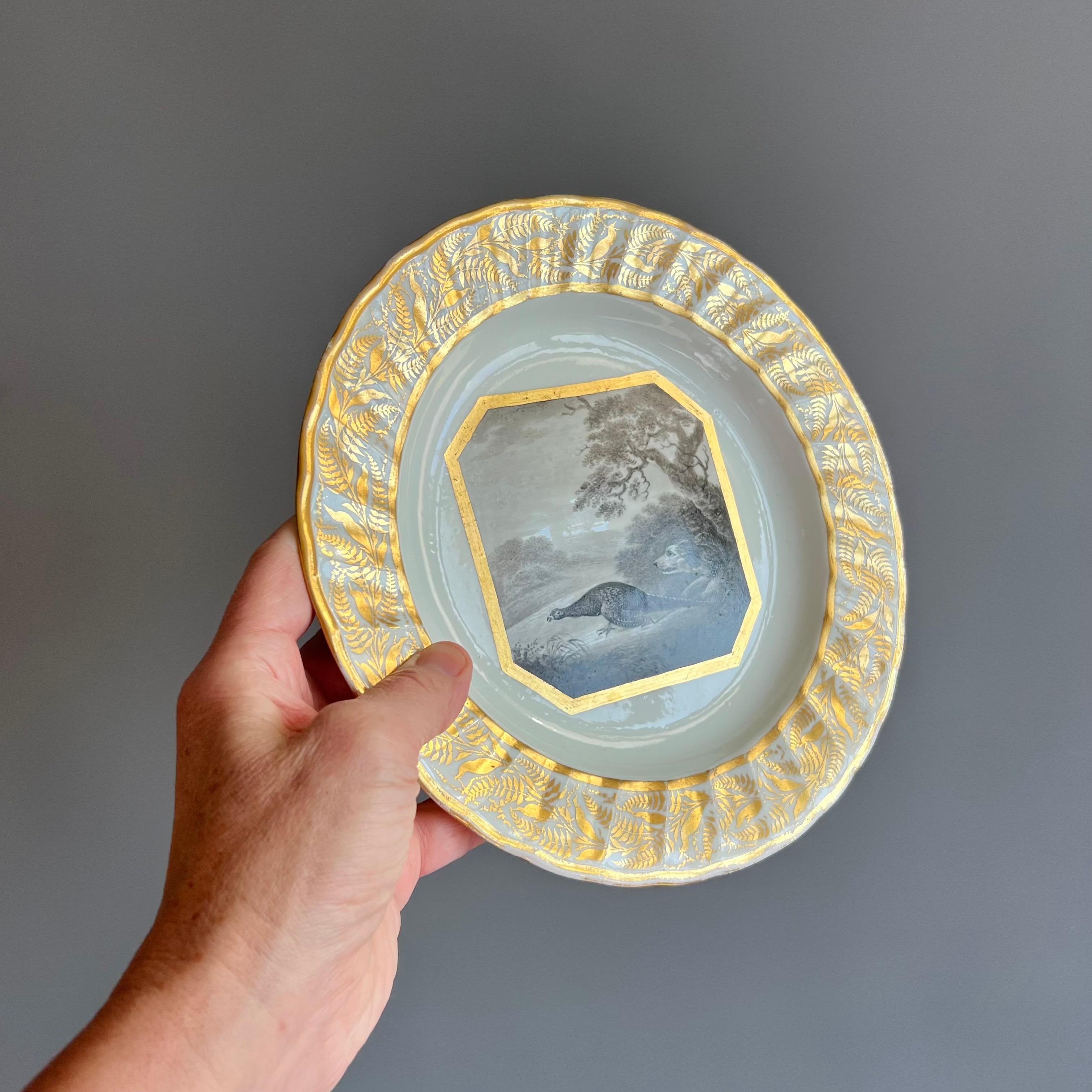 Si tratta di uno splendido e rarissimo piatto realizzato da Derby tra il 1795 e il 1800 circa. Questo piatto non è solo bello, è un vero pezzo di storia.

Il piatto ha un bel bordo a coste con un delicato motivo dorato e una splendida scena di